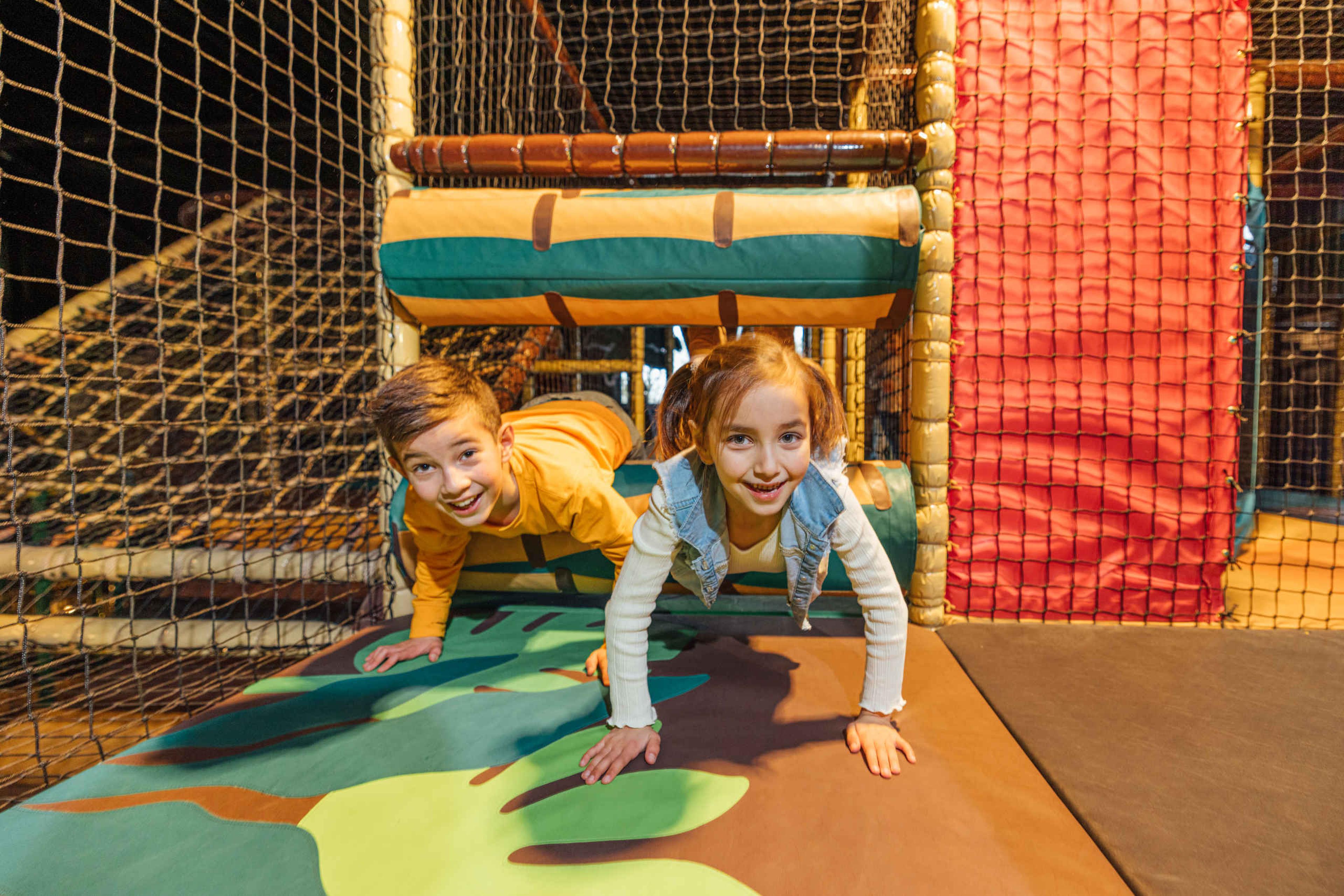 Twee kinderen spelen in een speeltoestel in Speelland Indoor Beekse Bergen.