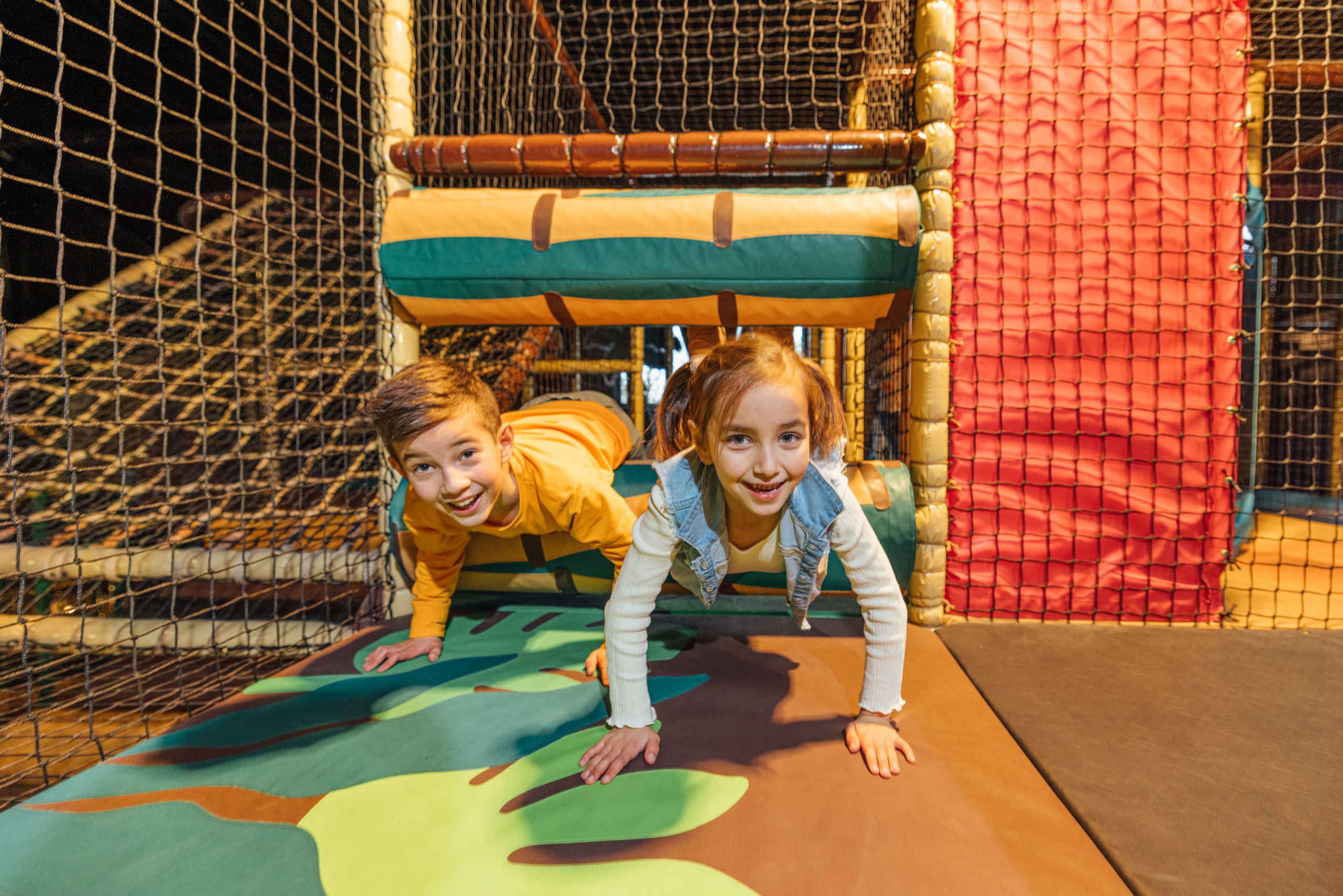 Twee kinderen spelen in een speeltoestel in Speelland Indoor Beekse Bergen.