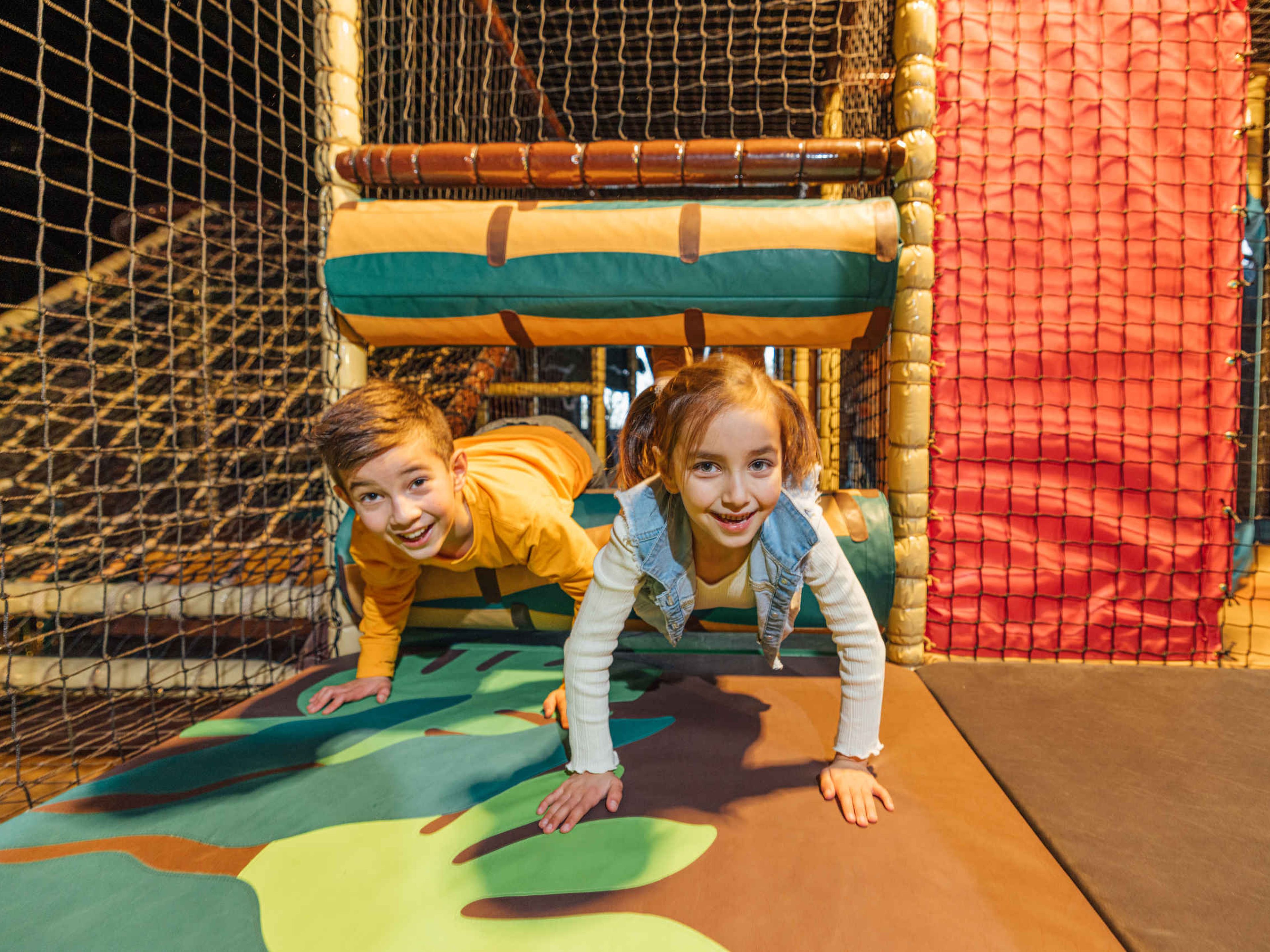 Twee kinderen spelen in een speeltoestel in Speelland Indoor Beekse Bergen.