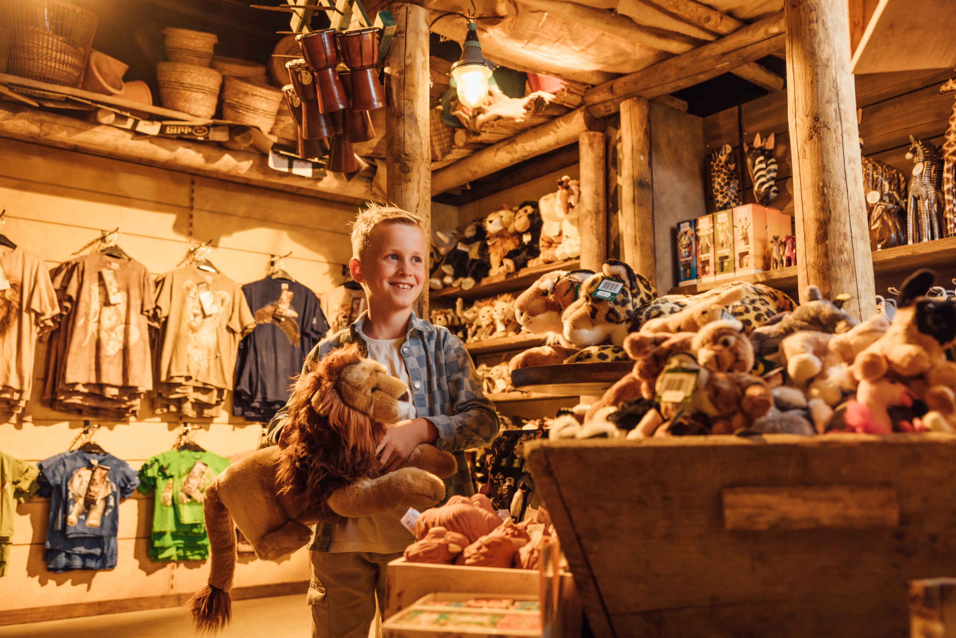 Souvenirshop in Mugunda jongen met een knuffel in Safaripark Beekse Bergen