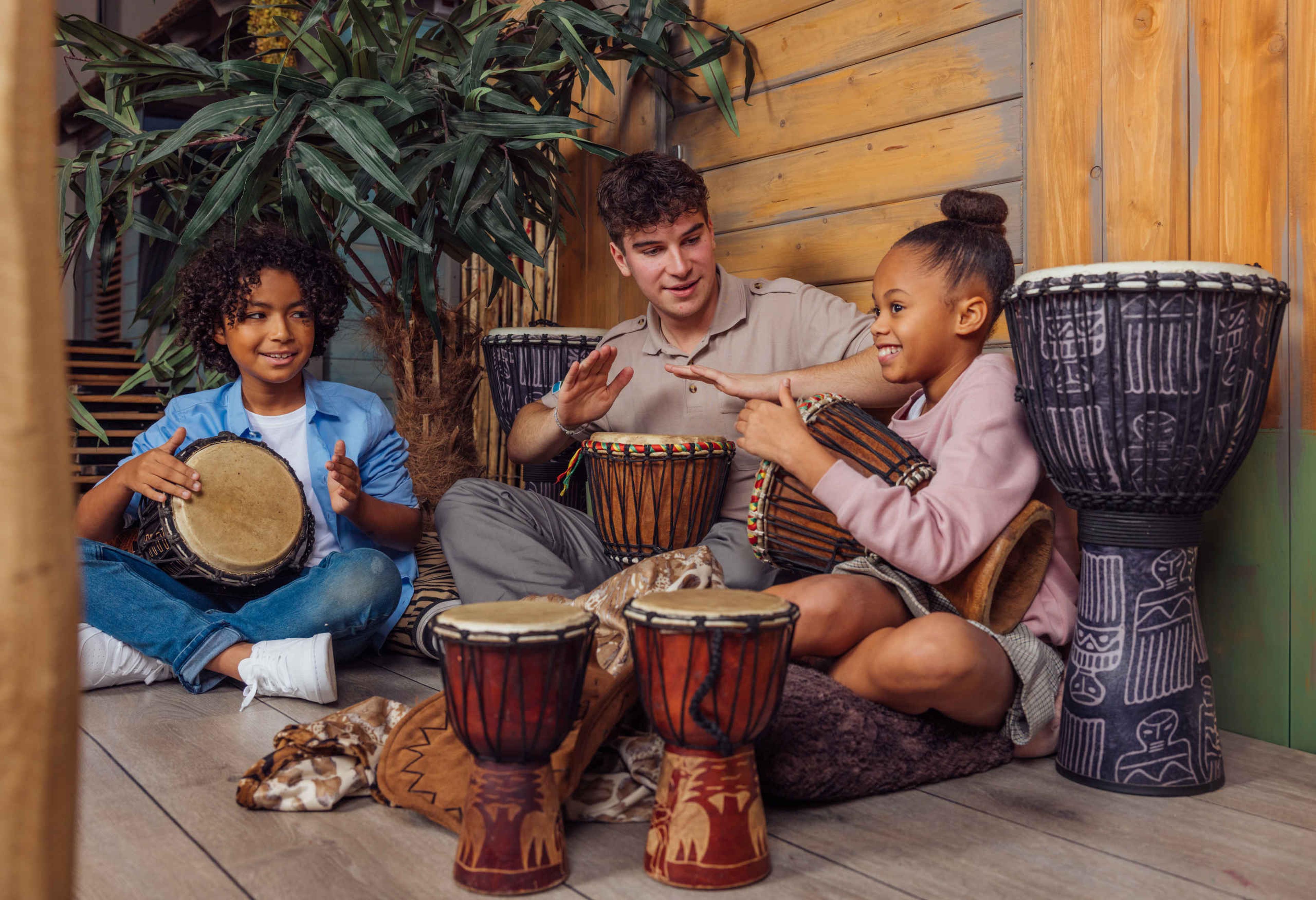 Het animatieteam leert twee kinderen djembé te spelen op het Safari Resort Beekse Bergen