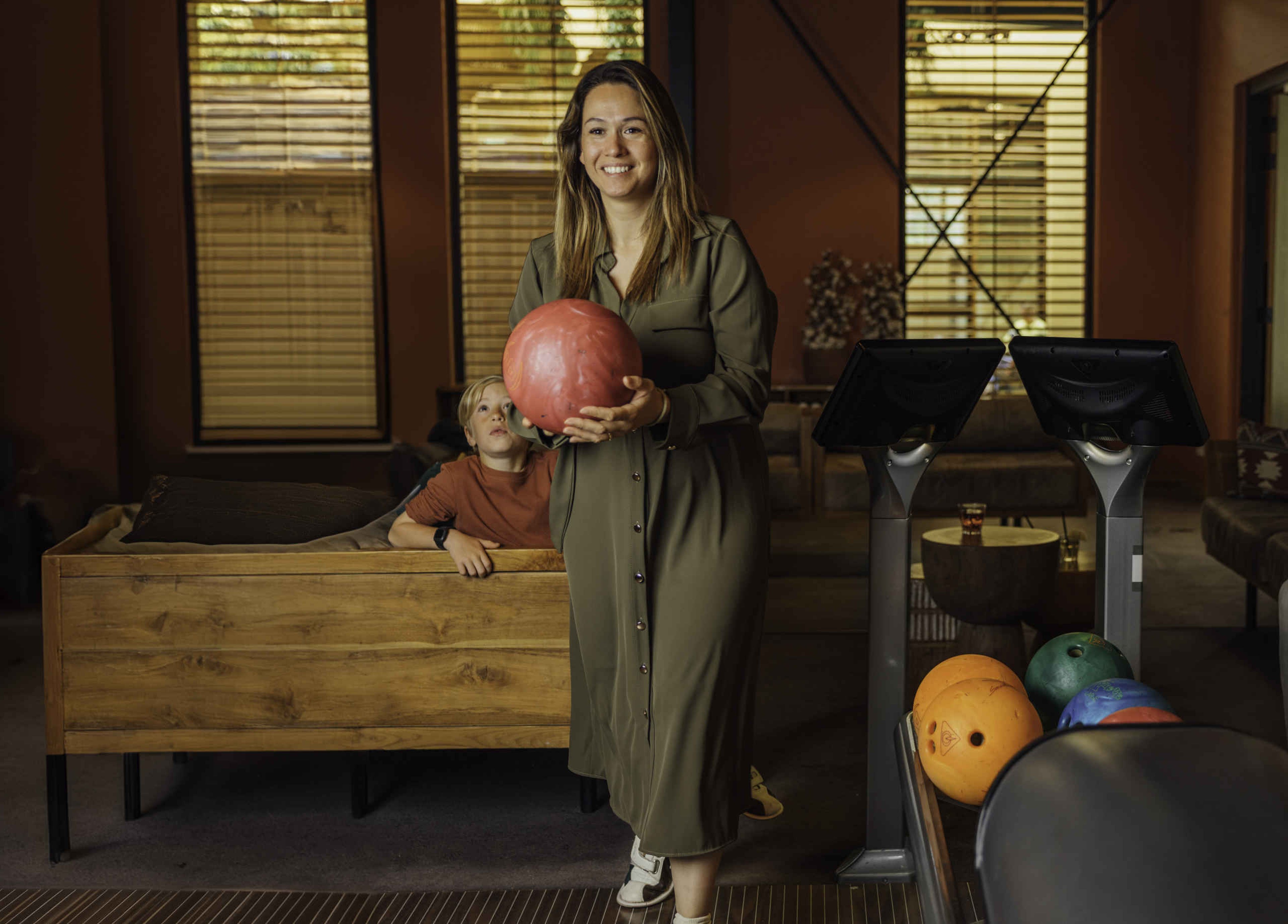 Een vrouw gaat met haar gezin bowlen op Safari Resort Beekse Bergen dat je kunt reserveren als je overnacht bij Safari Hotel Beekse Bergen.