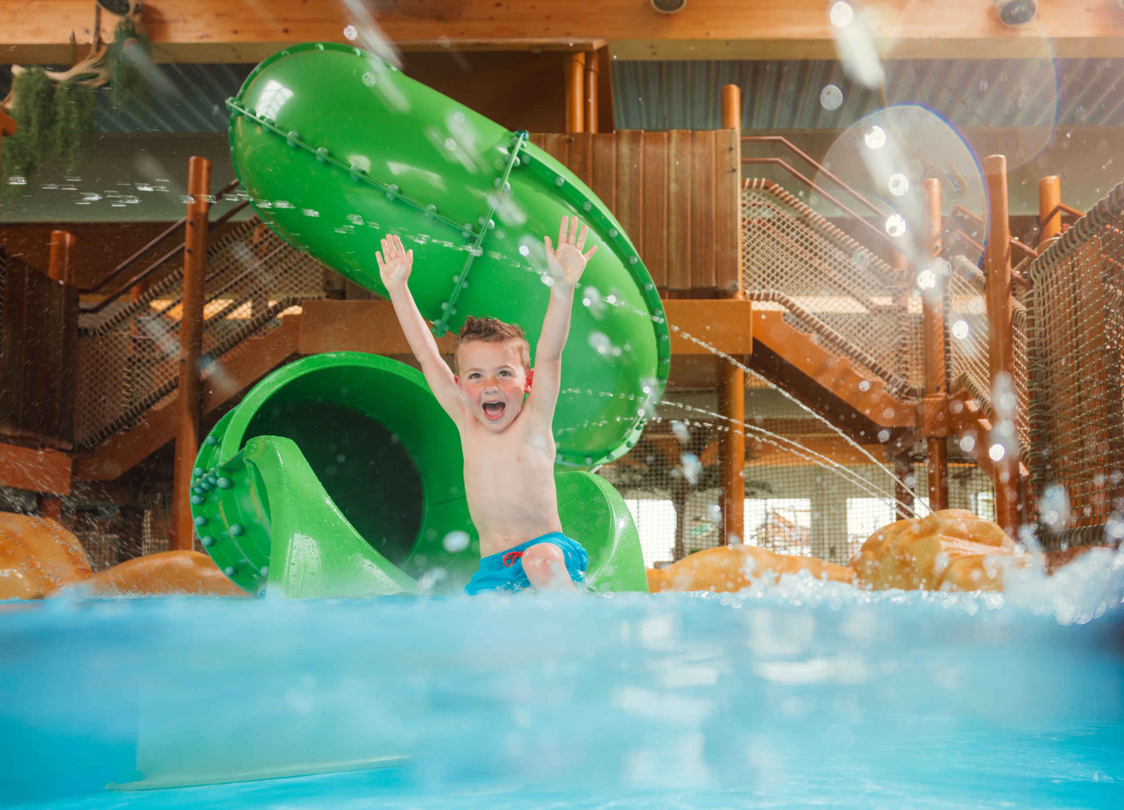 Een jongen gaat van de glijbaan bij Etsi Pool in Lake Resort Beekse Bergen.