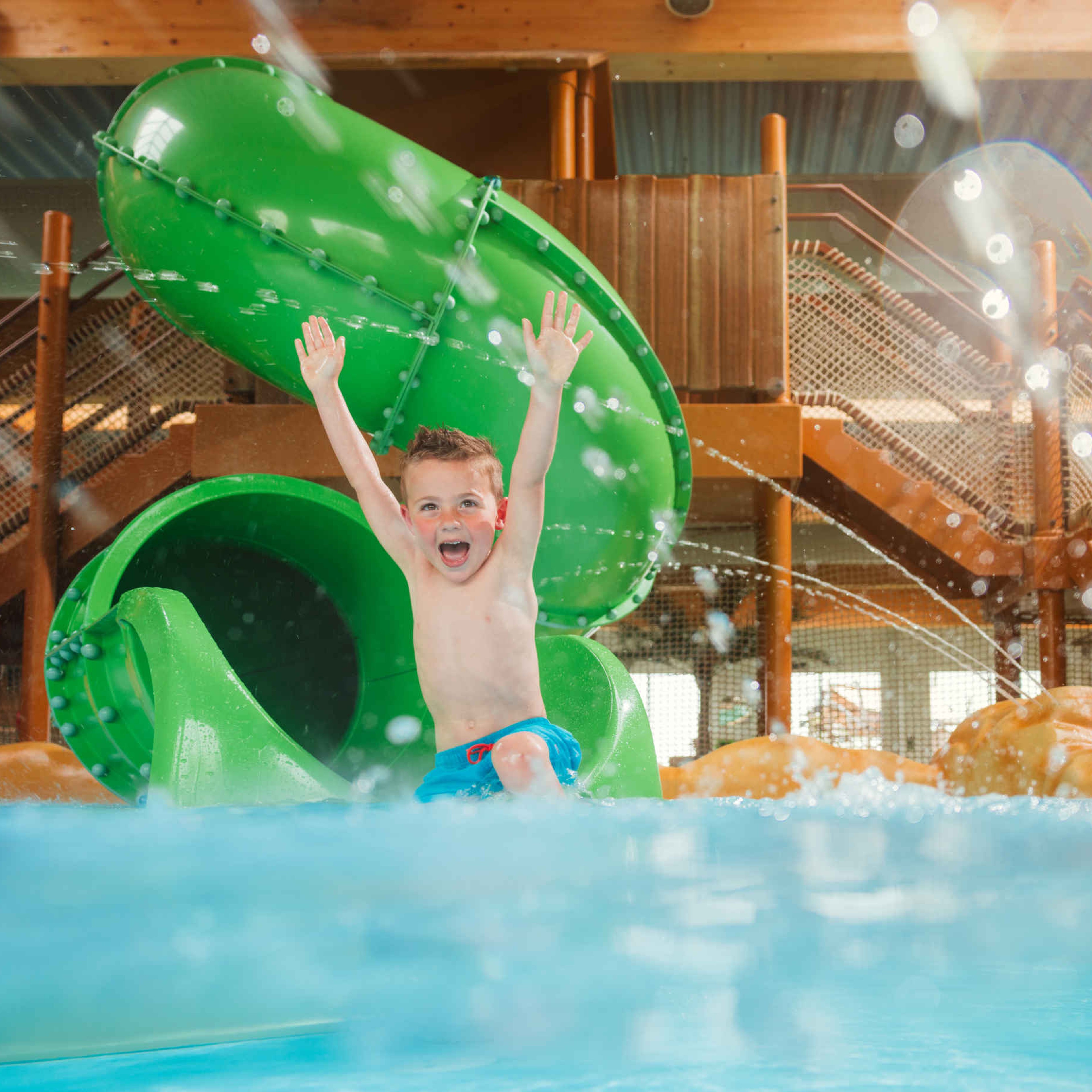 Een jongen gaat van de glijbaan bij Etsi Pool in Lake Resort Beekse Bergen.