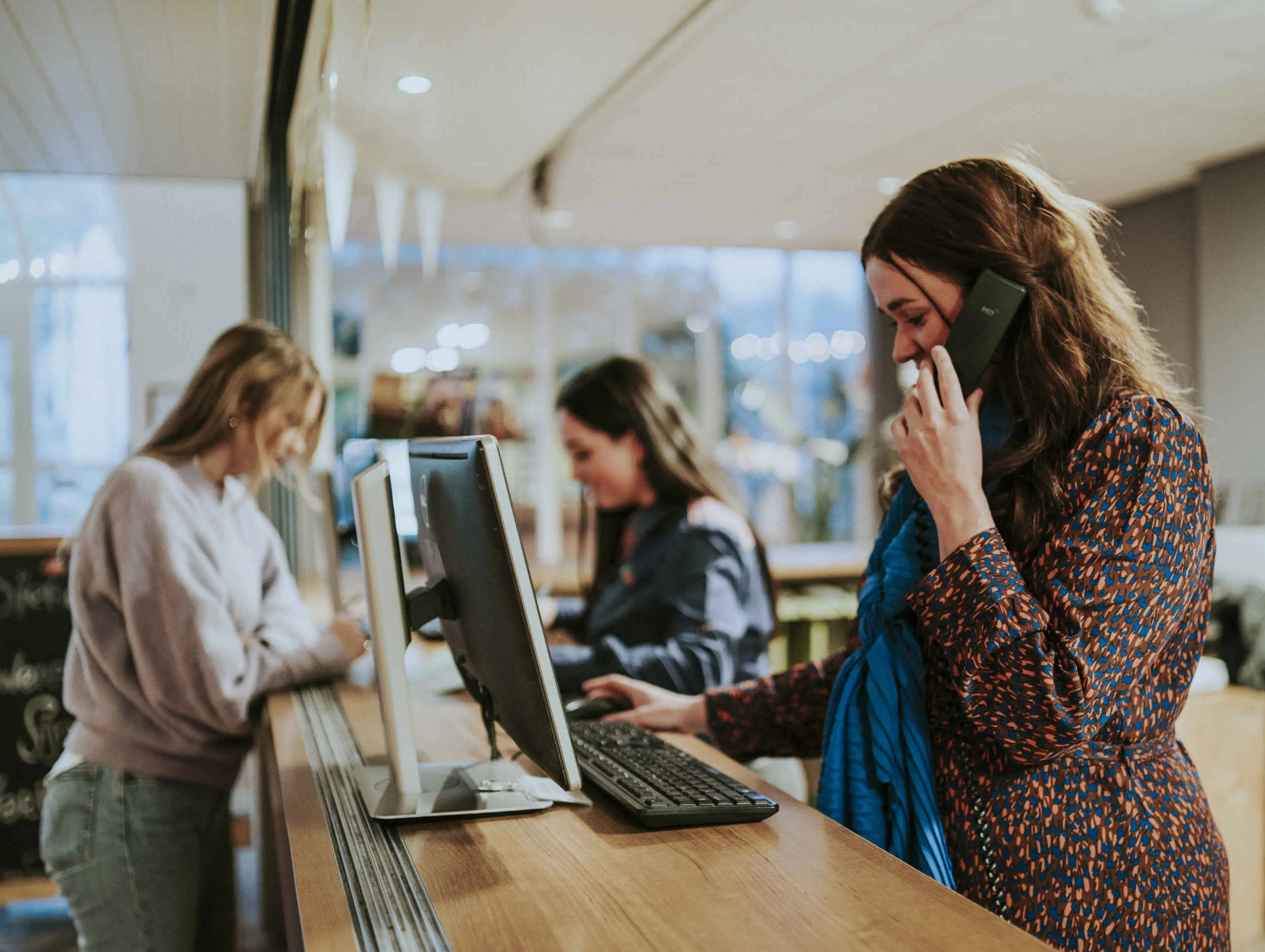 Een receptioniste neemt de telefoon op bij Vakantiepark Dierenbos.
