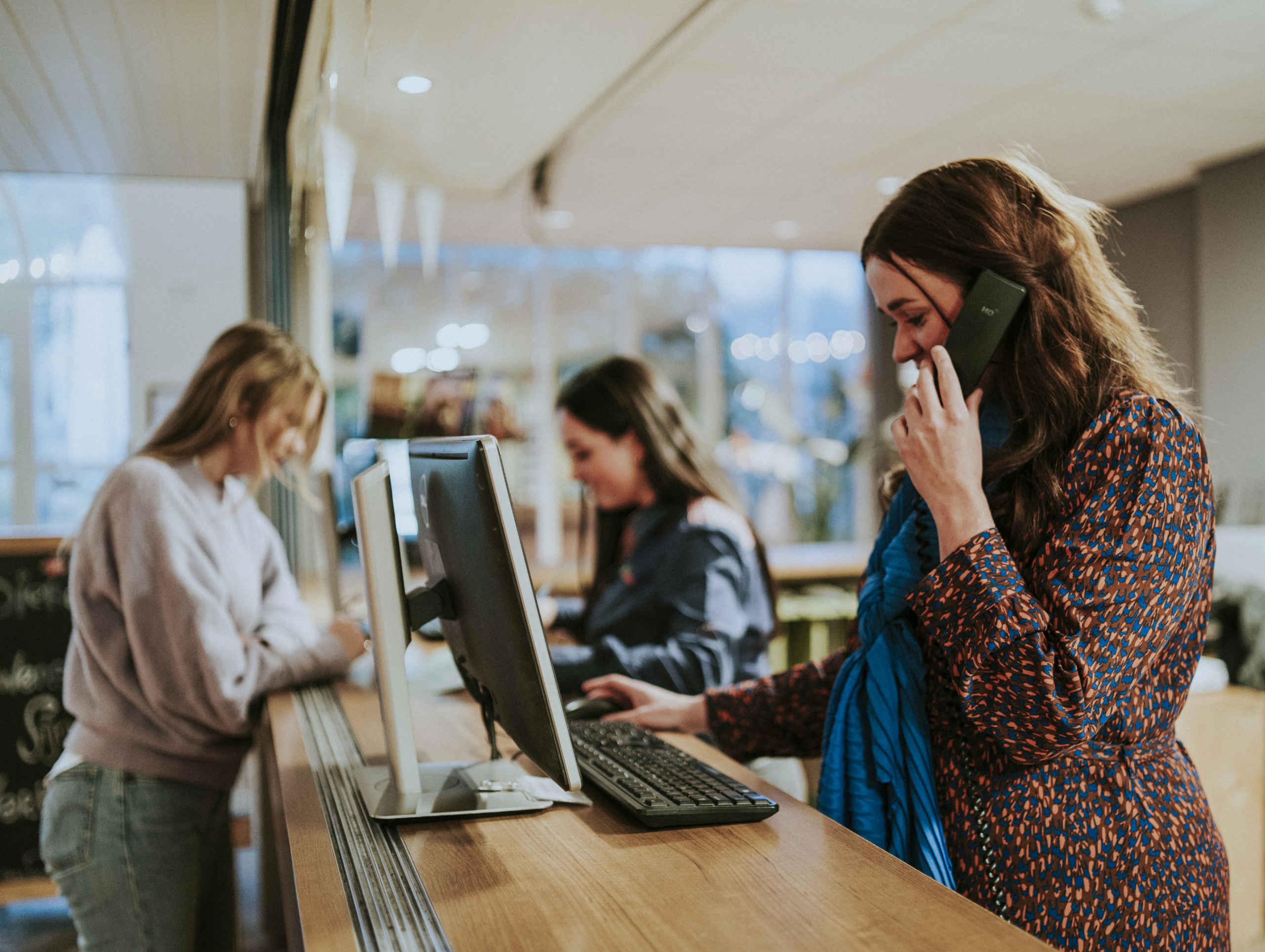 Een receptioniste neemt de telefoon op bij Vakantiepark Dierenbos.