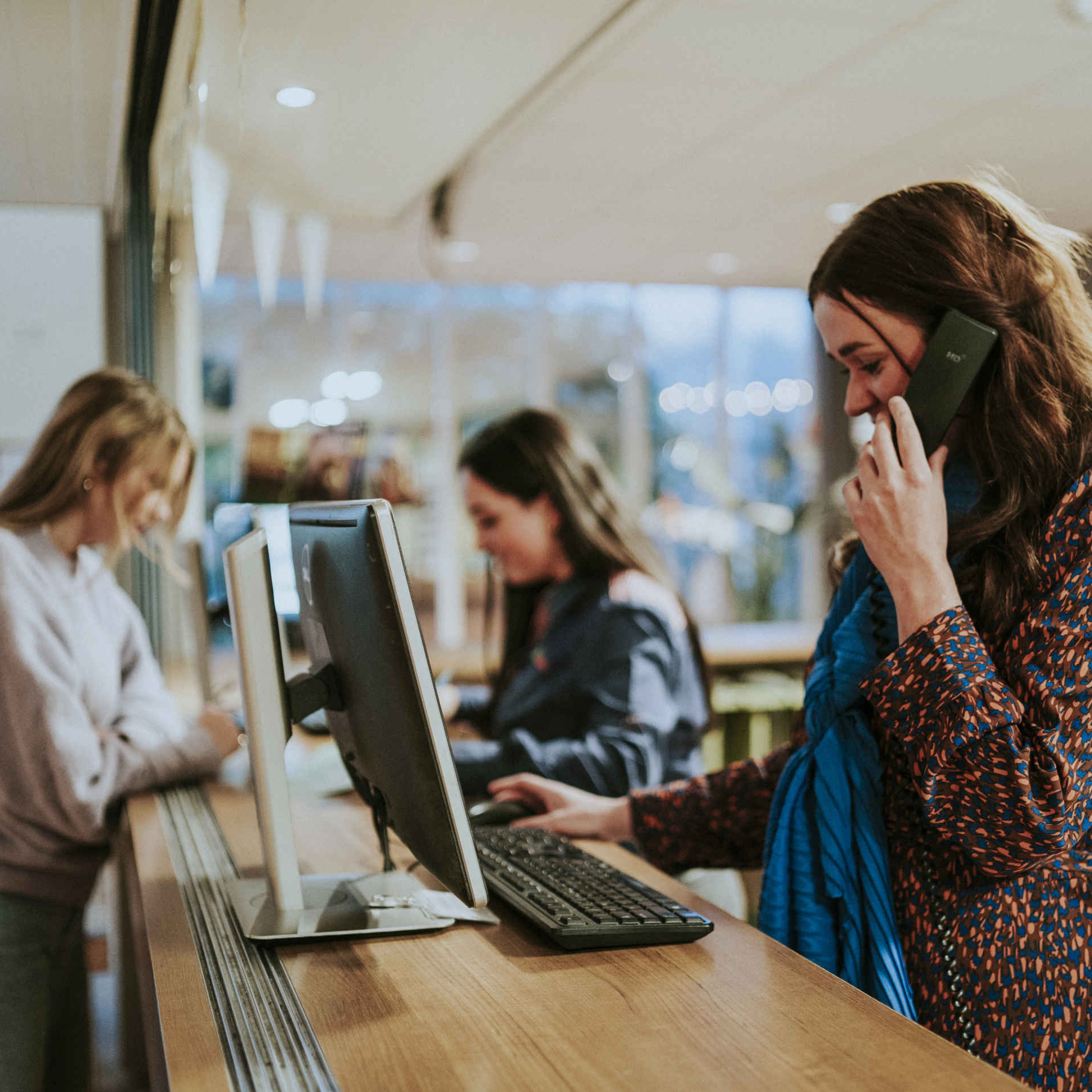 Een receptioniste neemt de telefoon op bij Vakantiepark Dierenbos.