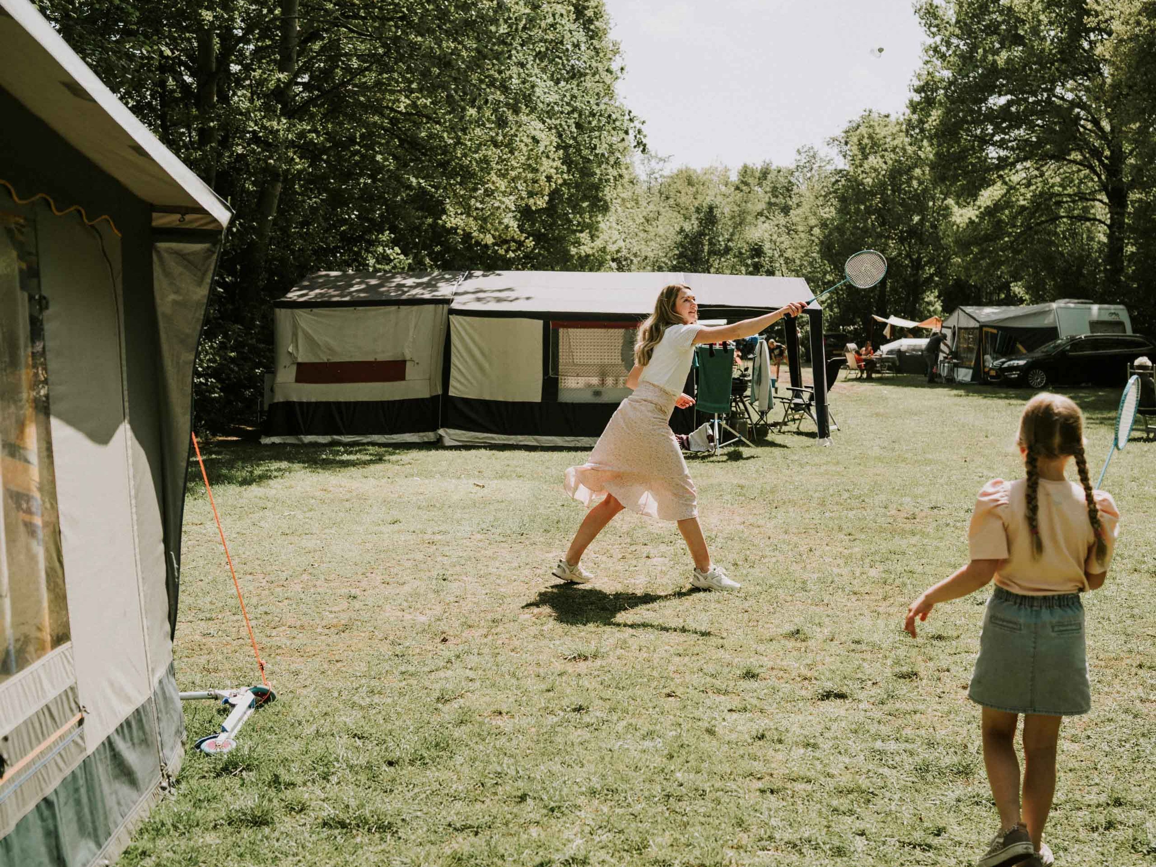 Moeder en kind aan het badmintonnen op het kampeerterrein van Vakantiepark Dierenbos
