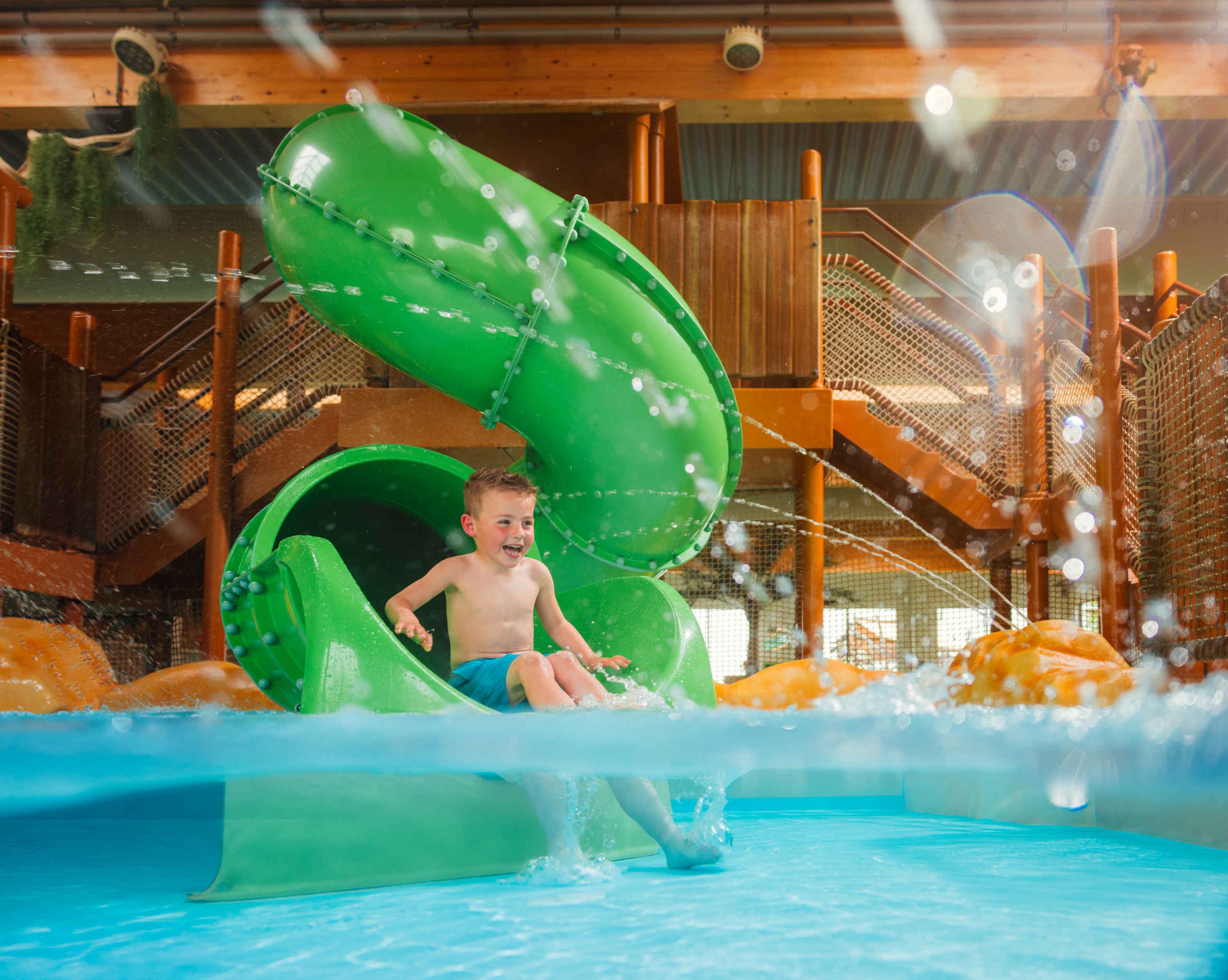 Een jongen gaat van de glijbaan bij Etsi Pool op Lake Resort Beekse Bergen.