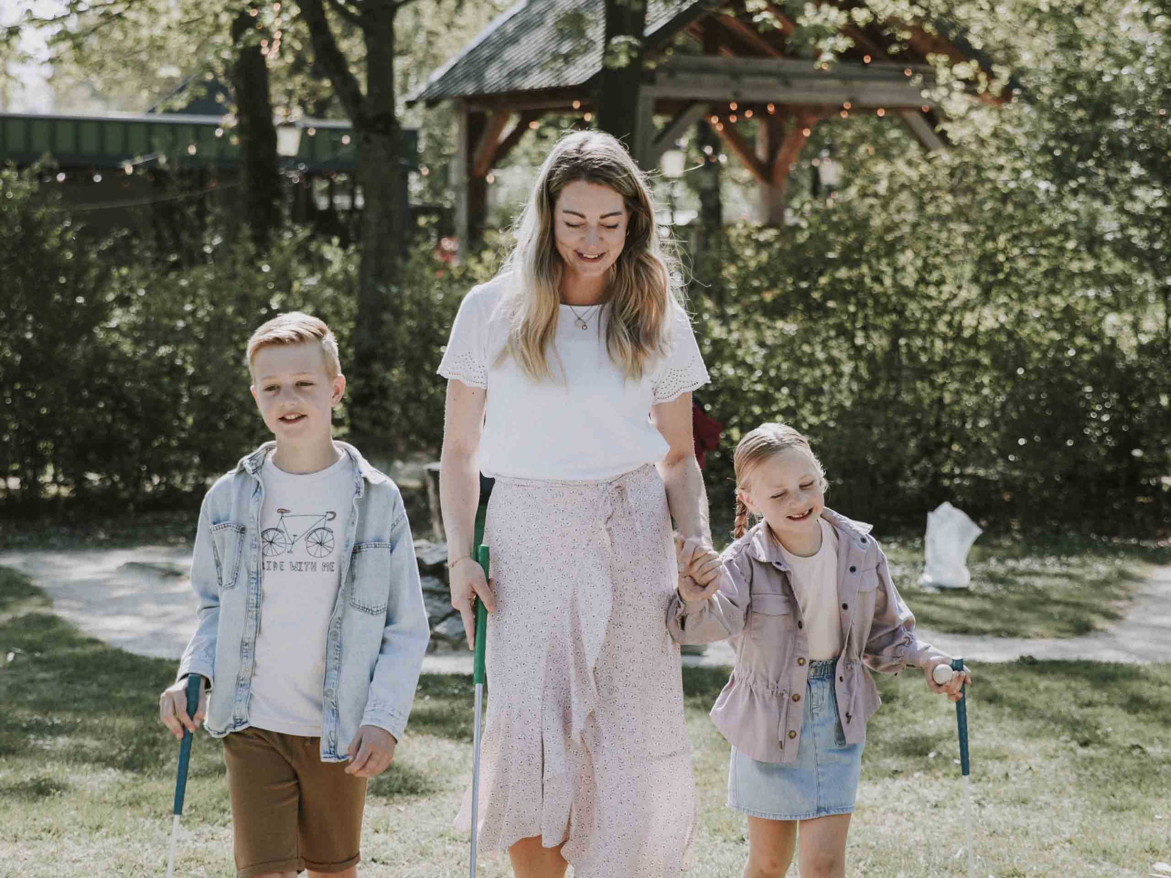 Moeder met kinderen op de midgetgolfbaan van Vakantiepark Dierenbos