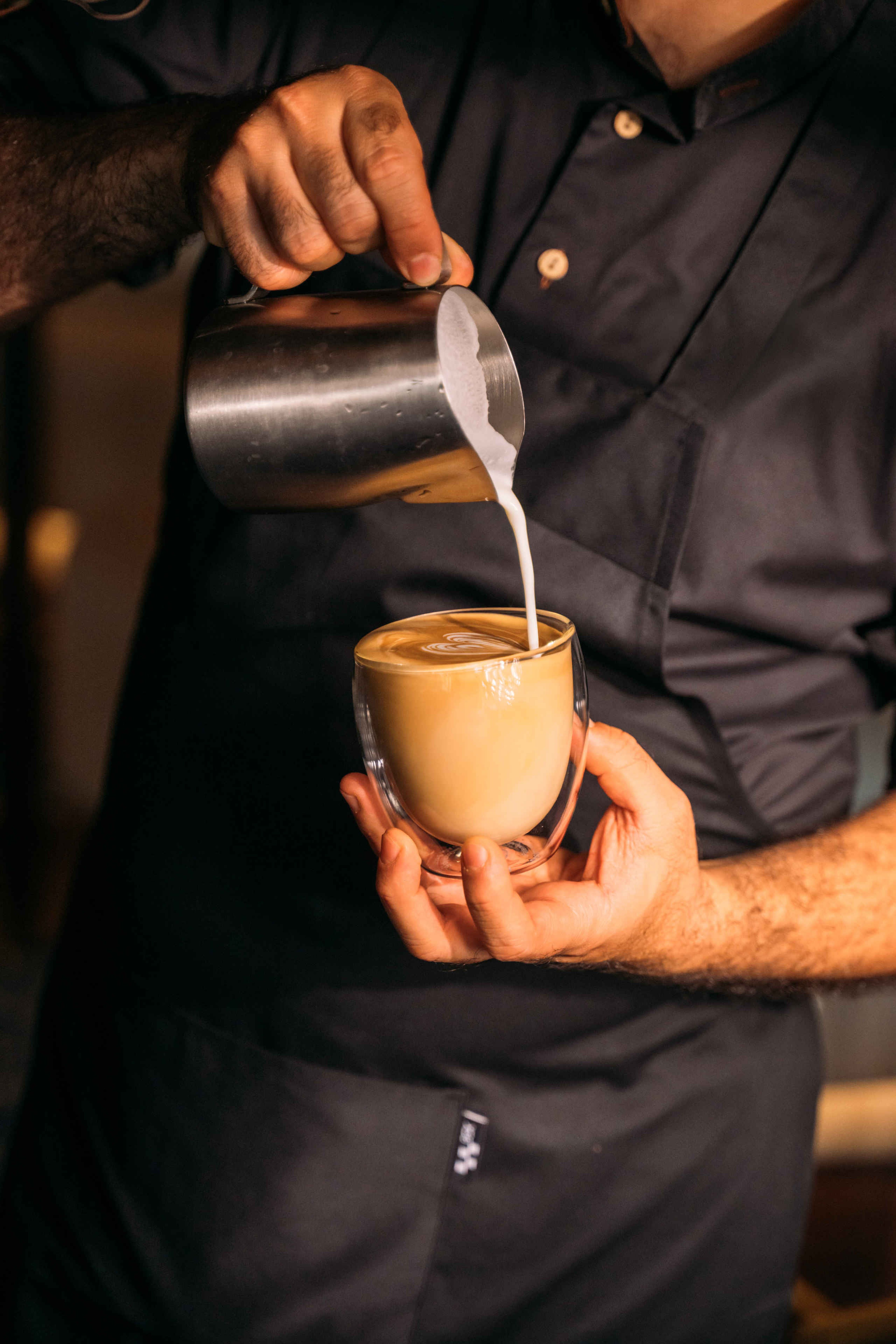 Barista schenkt een cappuccino in Bar & Restaurant Nommos
