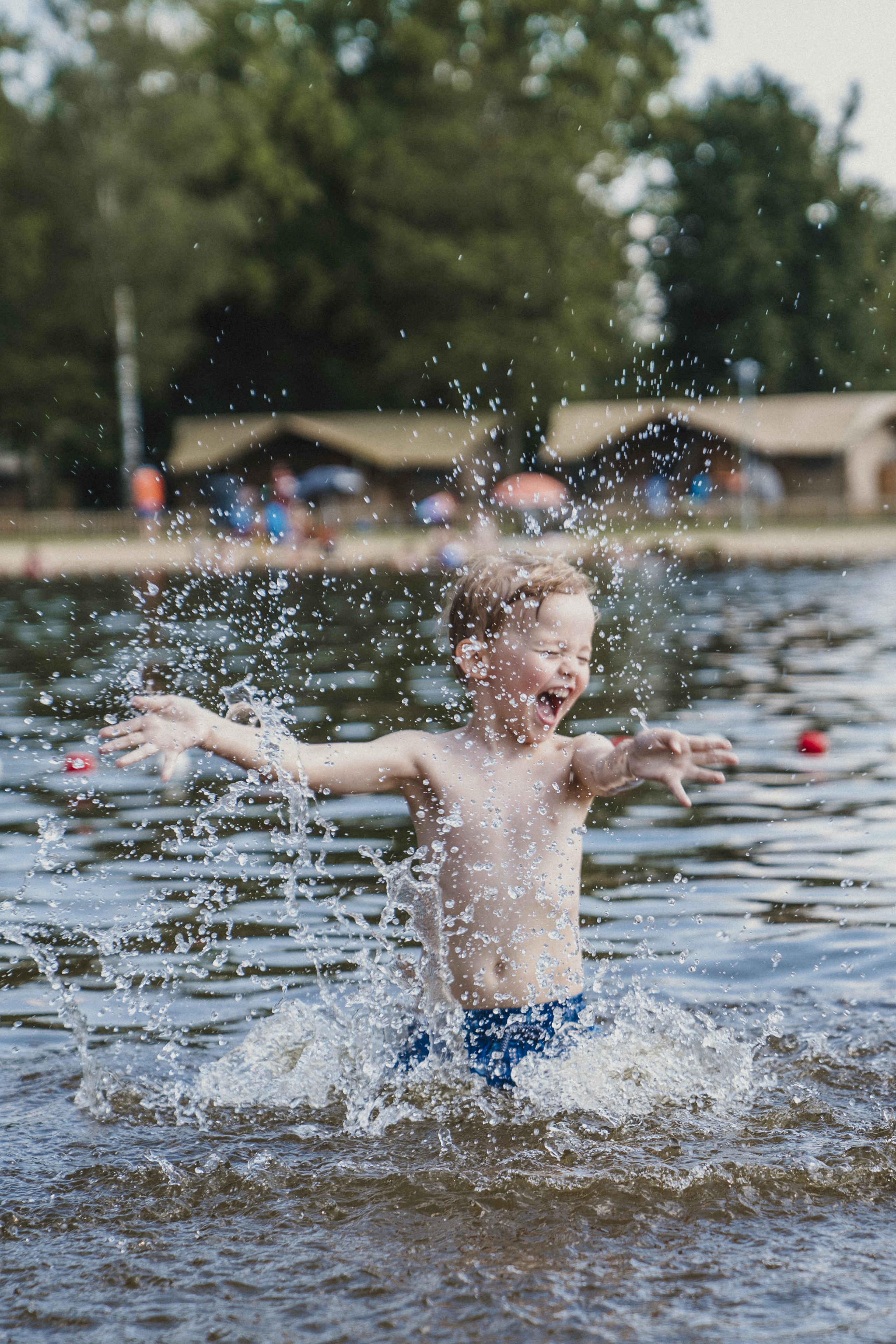 Een jongen speelt in de zwemvijver bij Vakantiepark Dierenbos