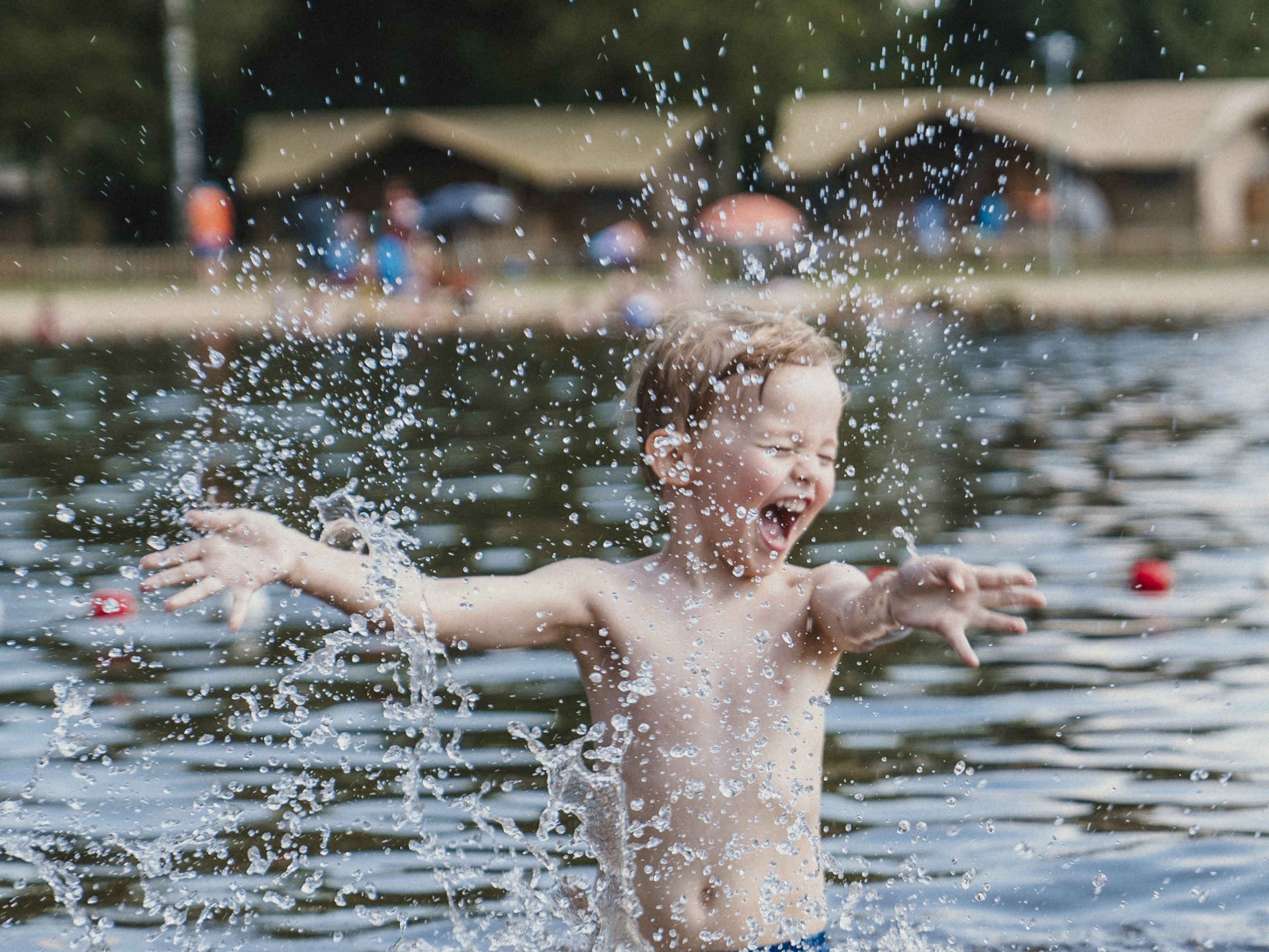 Een jongen speelt in de zwemvijver bij Vakantiepark Dierenbos