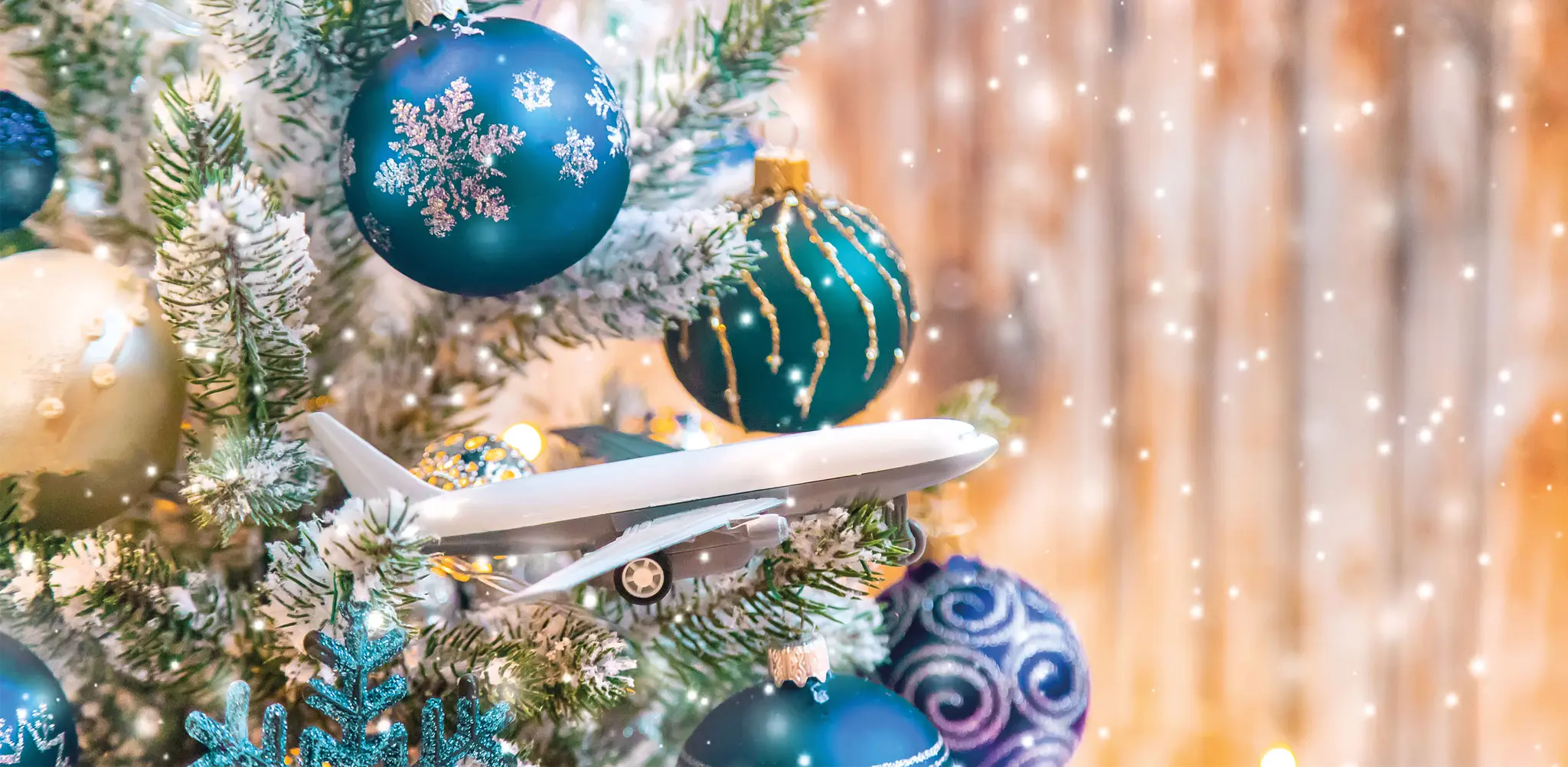 Een kerstboom met kerstballen en een vliegtuig