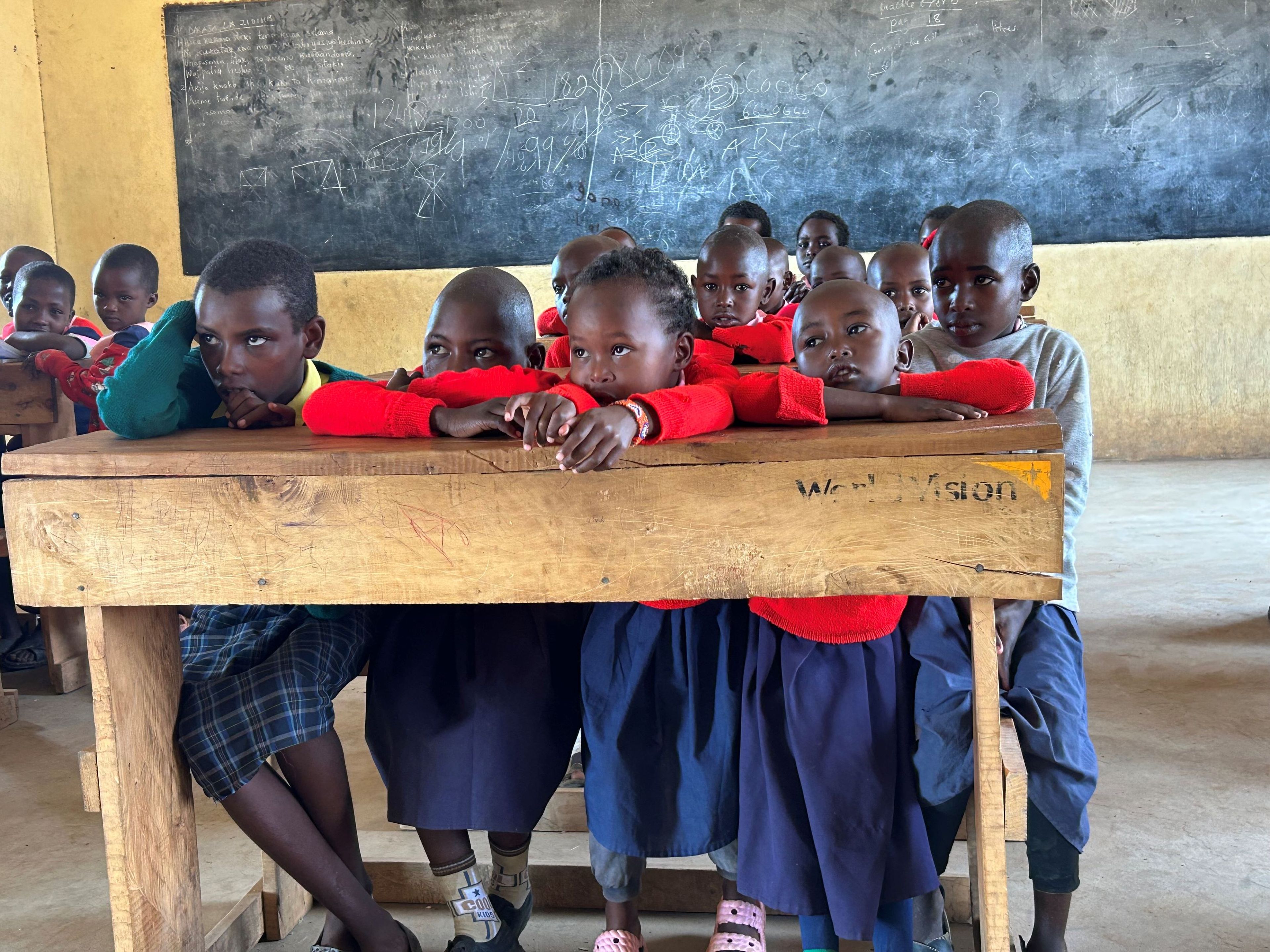 De schoolkinderen kijken naar Klaas-Jan en Yvonne in Kenia.