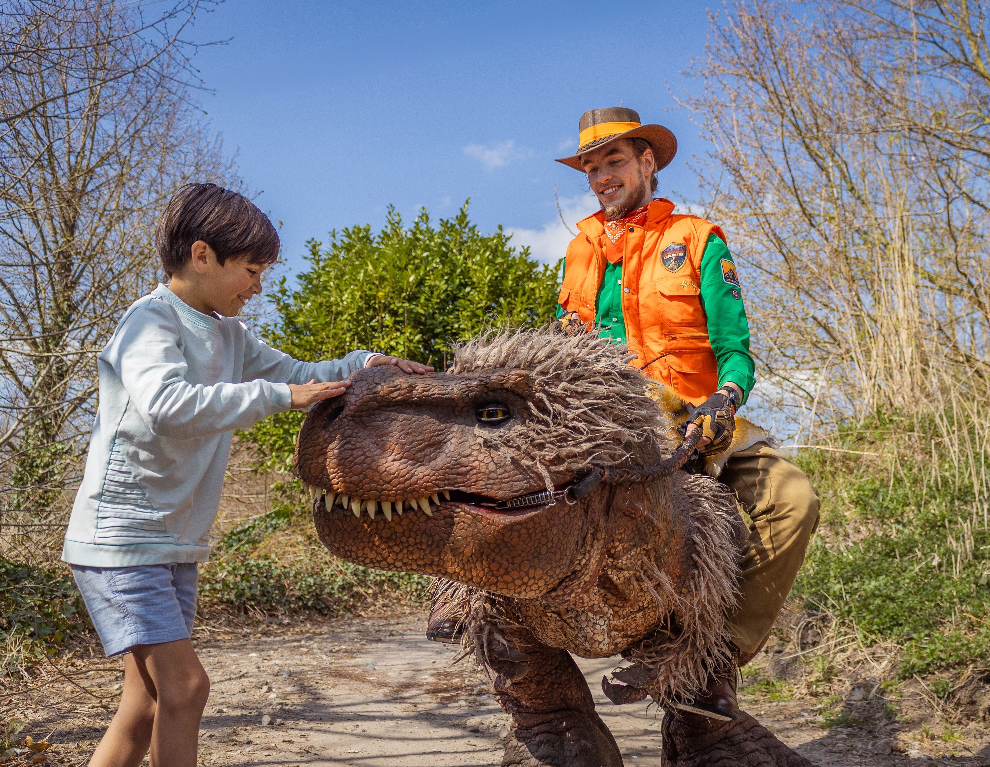 Een jongen aait de trex en staat bij de ranger bij DINO vs DIER in Eindhoven Zoo.