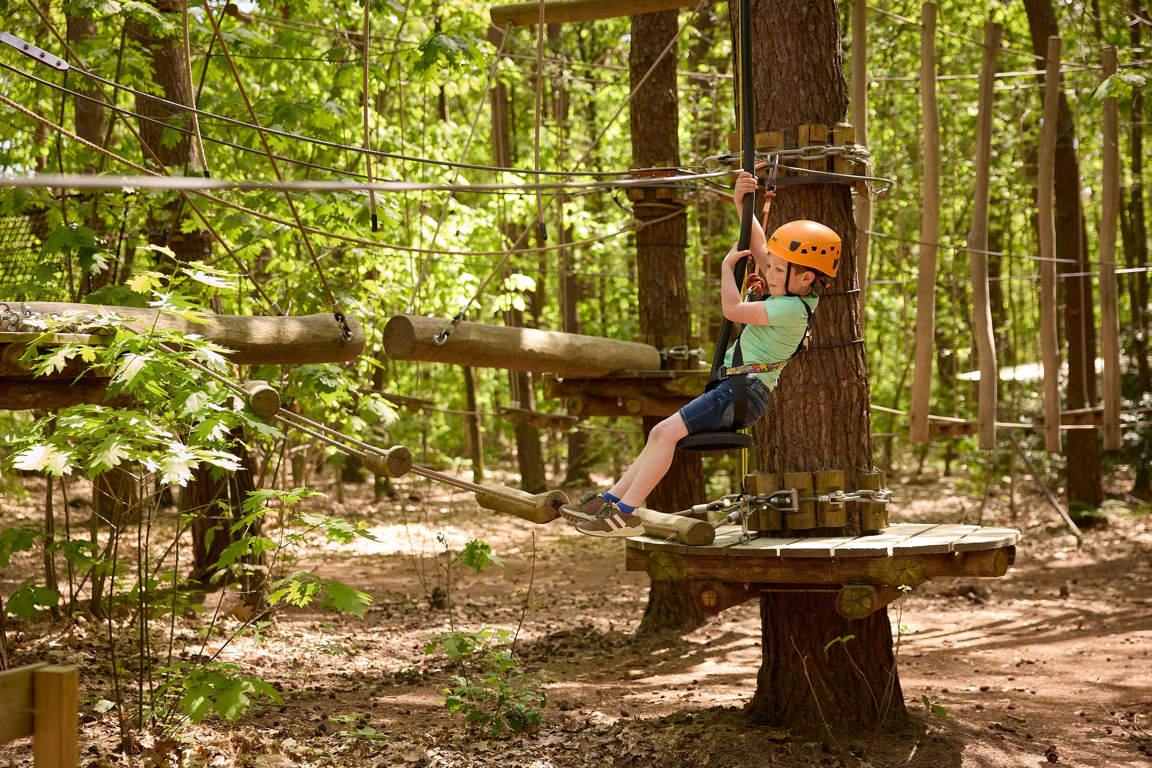 Jongen op obstakel bij zipline van Pico Parcours bij Klimrijk Brabant