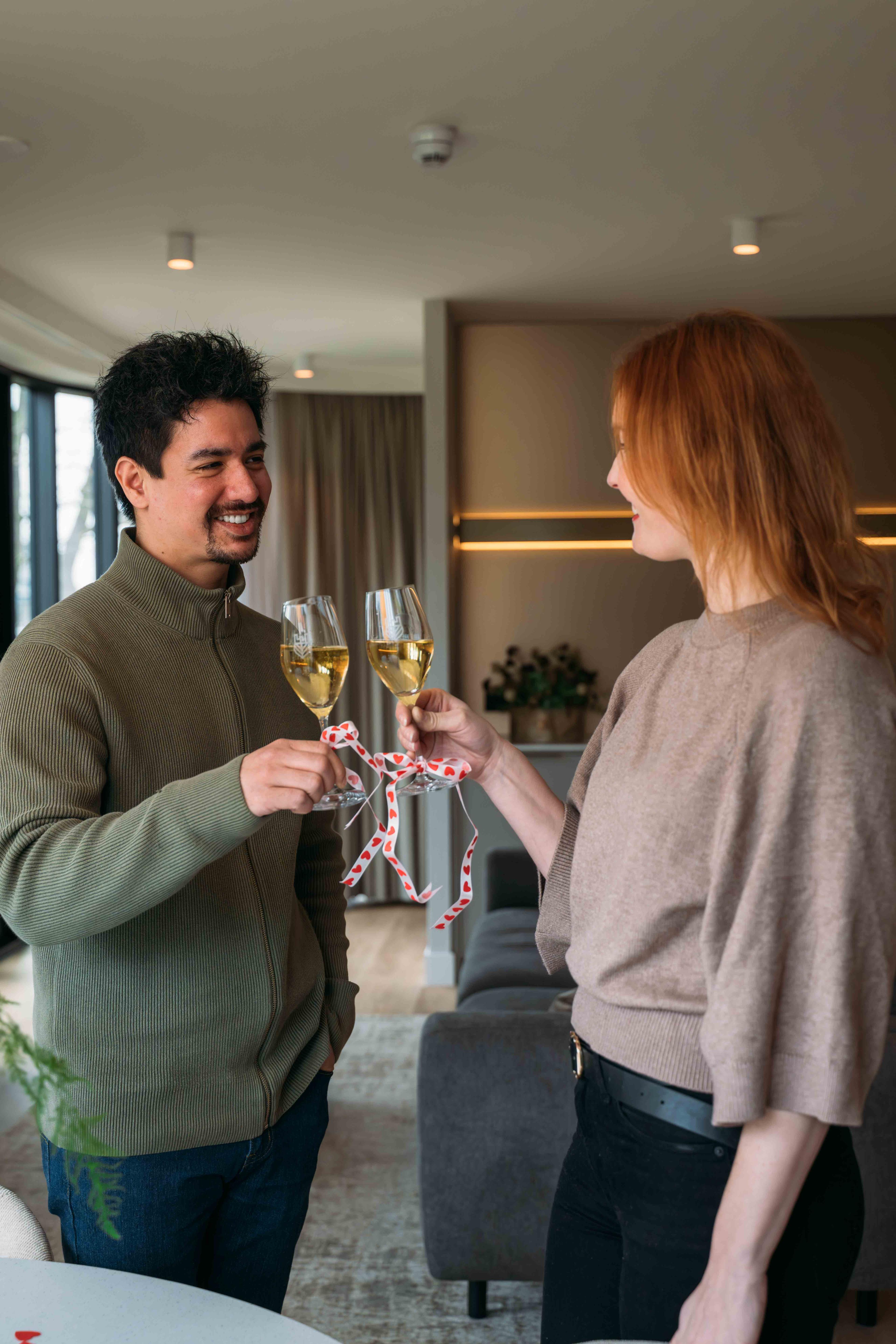 Koppel proost met champagne in suite in Kasteel Steenenburg