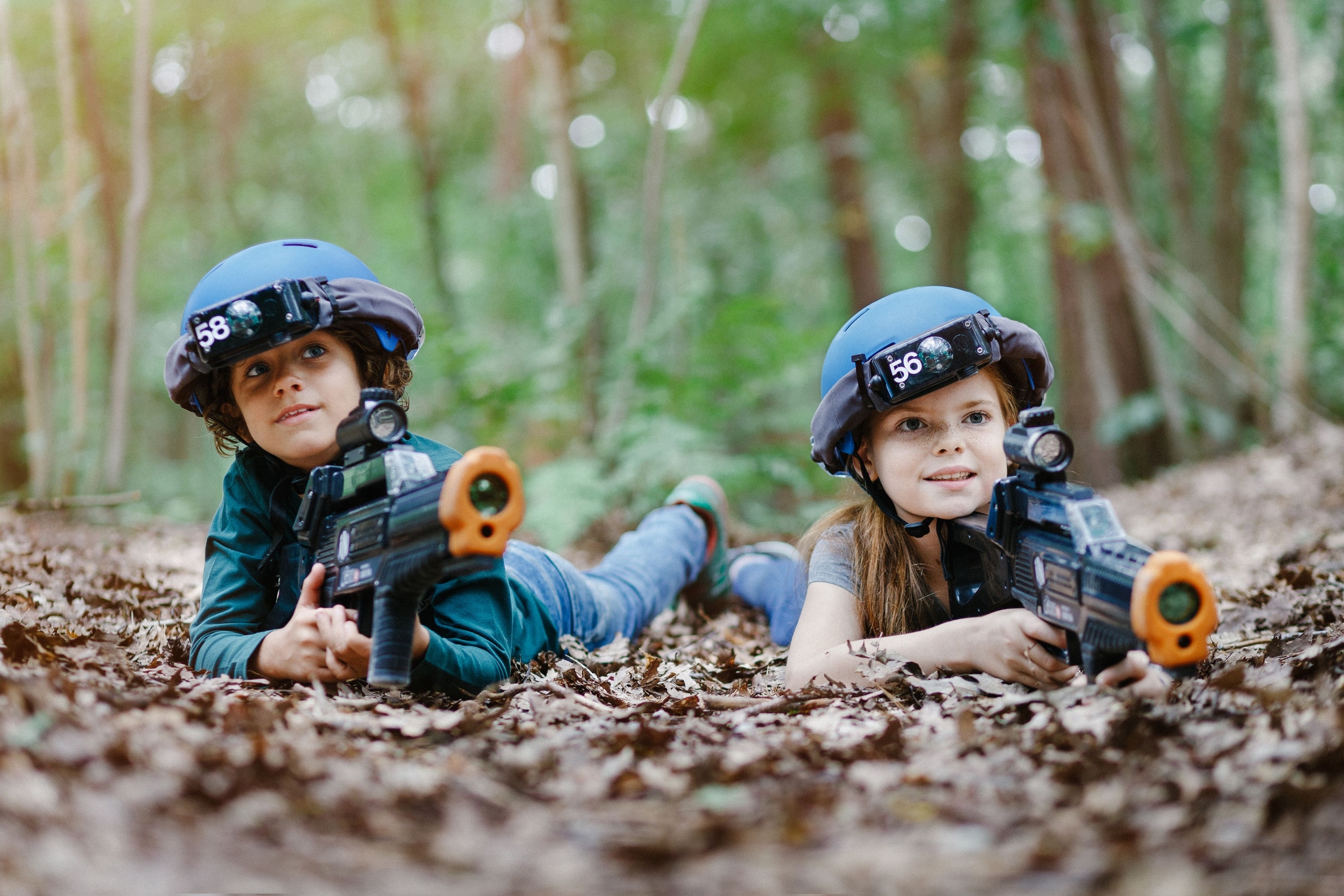Kinderen zijn aan het outdoor lasergamen tussen de bladeren bij Klimrijk Brabant