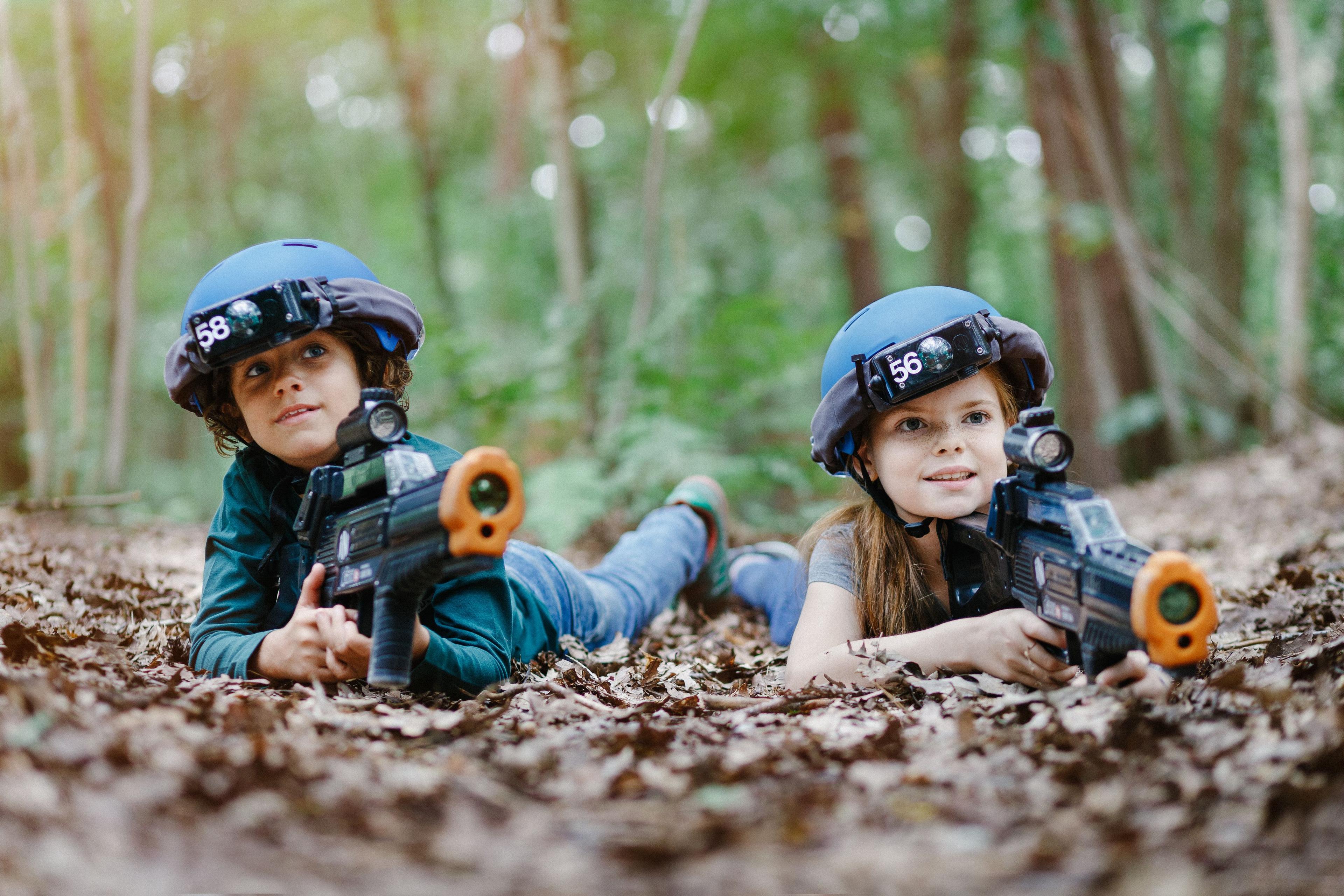 Kinderen zijn aan het outdoor lasergamen tussen de bladeren bij Klimrijk Brabant