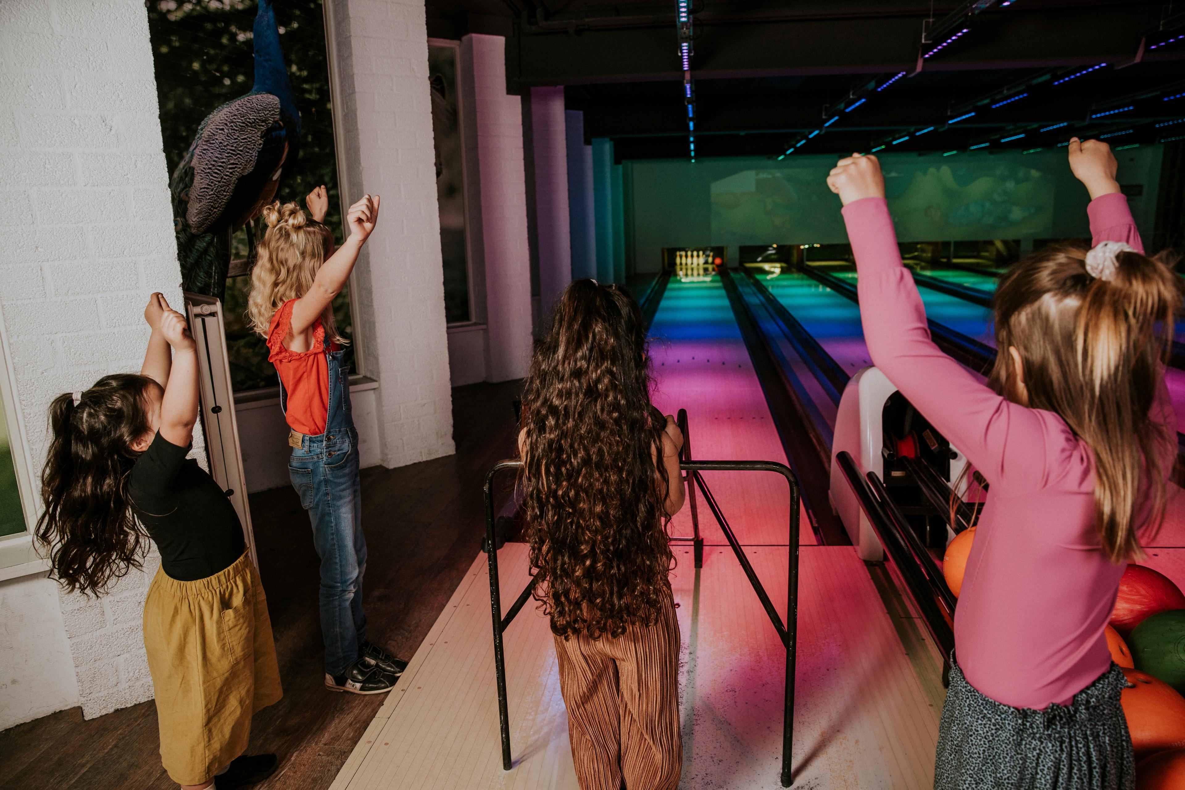 Kinderen juichen tijdens een kinderfeestje op de bowlingbaan van Vakantiepark Dierenbos
