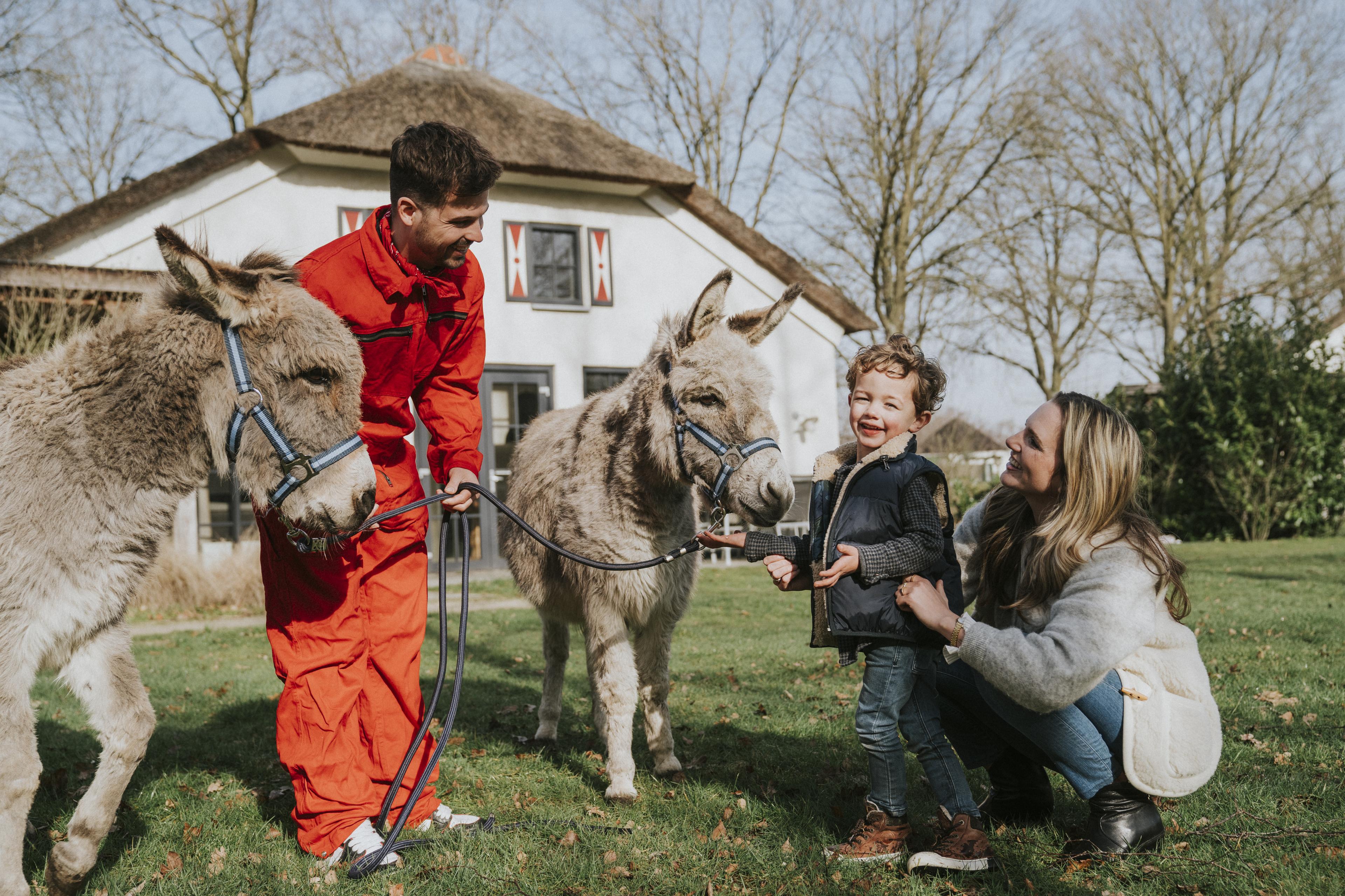 Gezin met kinderen bij dierenverzorger met ezel op Vakantiepark Dierenbos