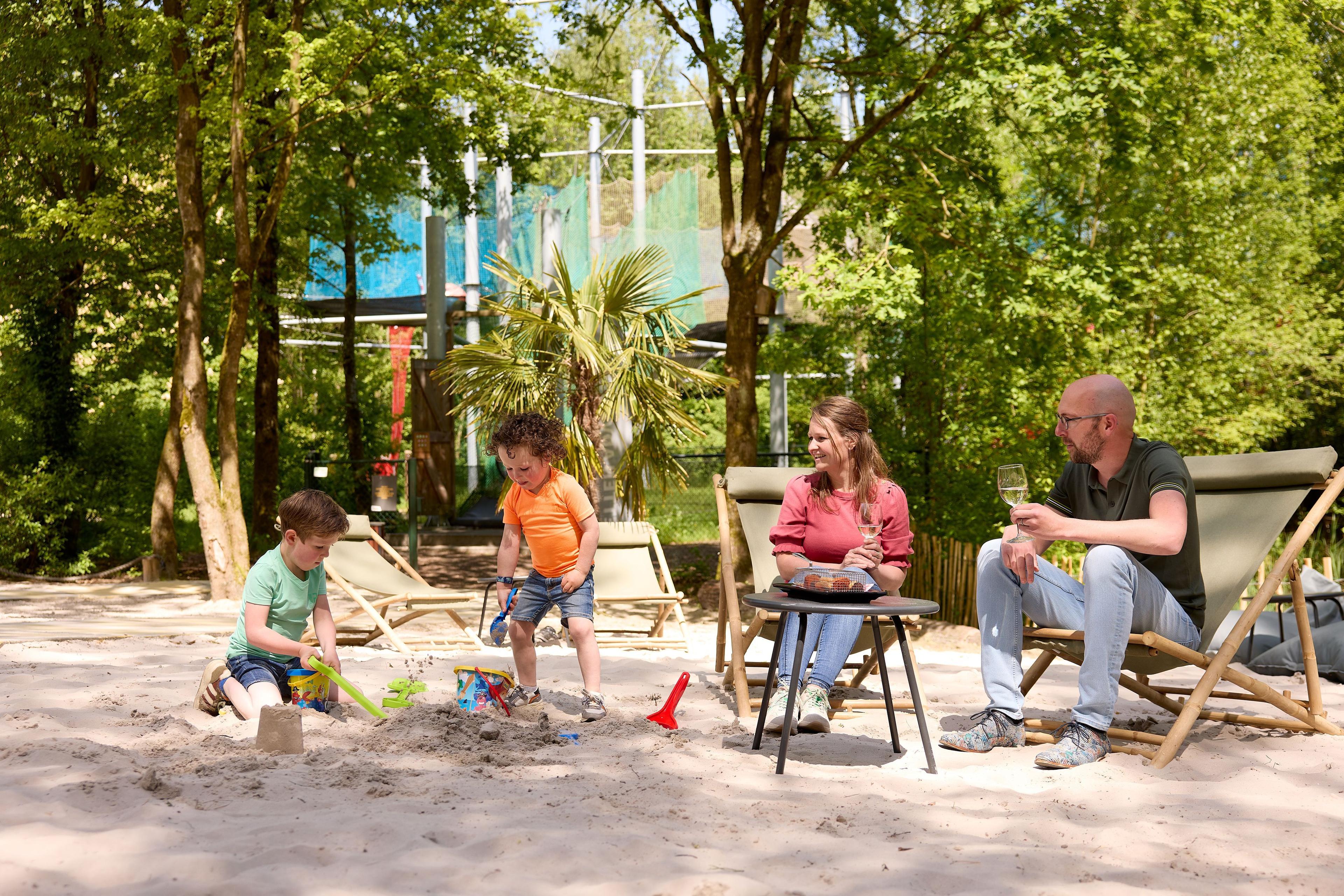 Gezin op het zandstrand van de Beach area bij Klimrijk Brabant