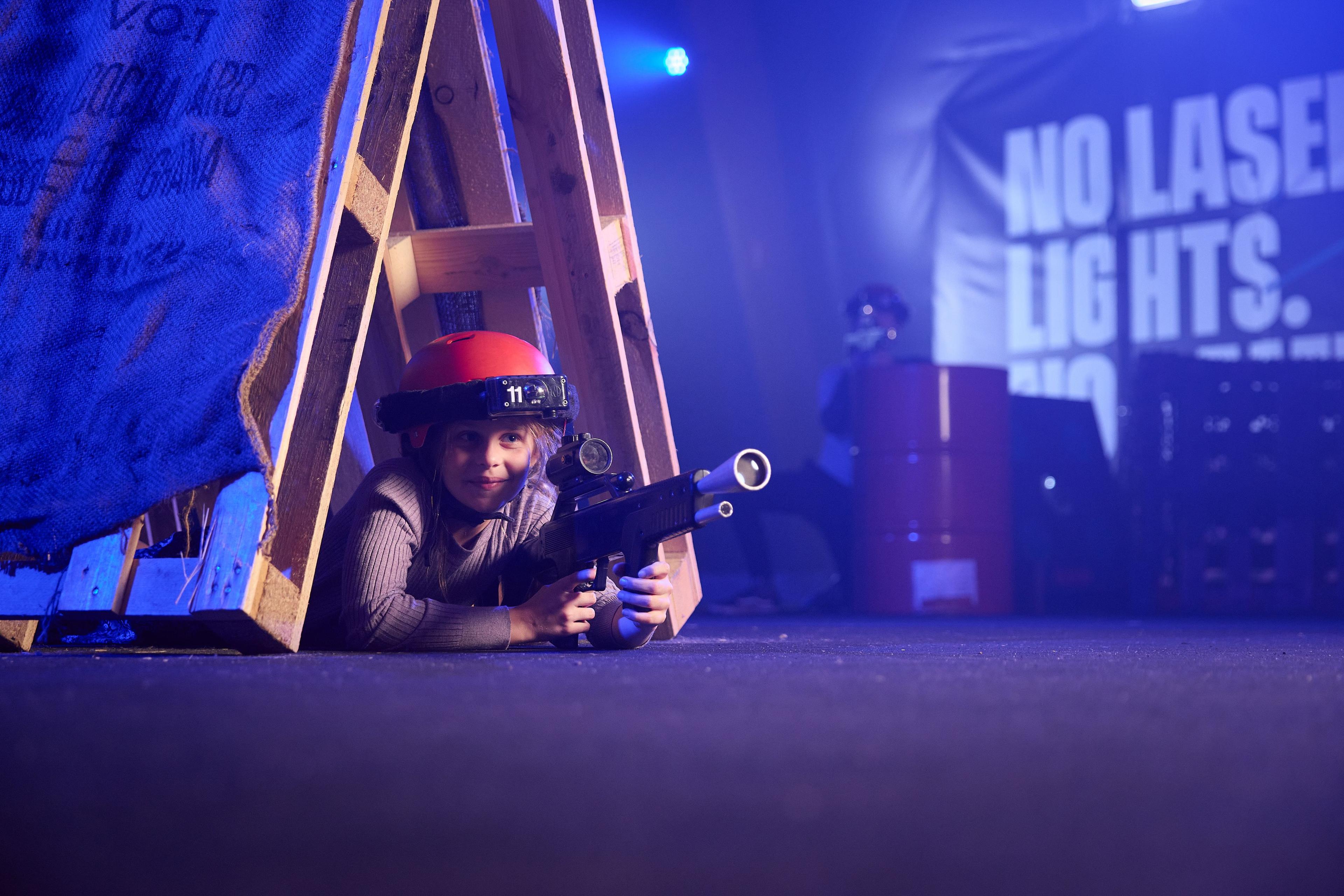 Kind verstopt in hindernis tijdens indoor lasergamen bij Klimrijk Brabant