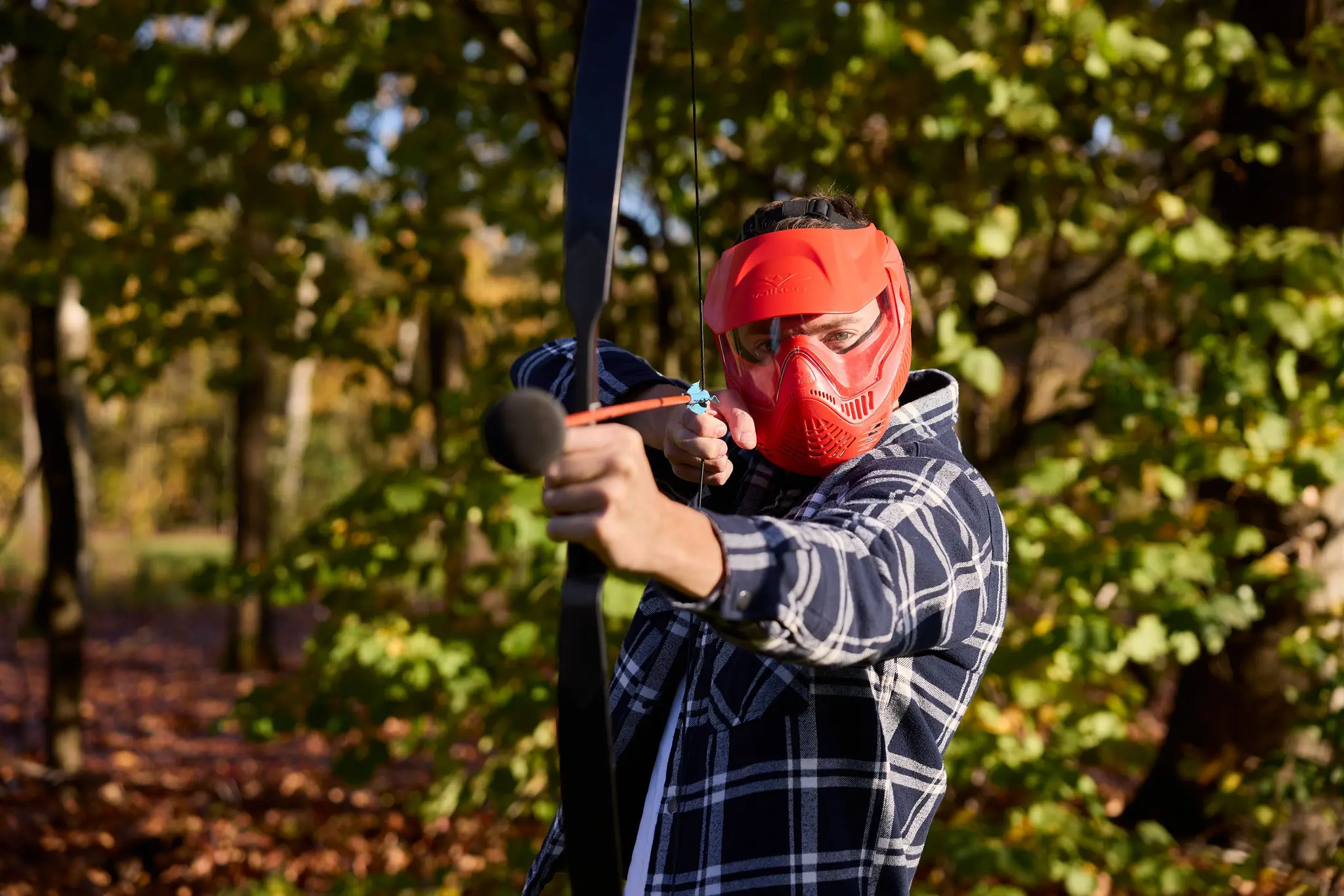 Man schiet een pijl tijdens outdoor archery tag bij Klimrijk Brabant