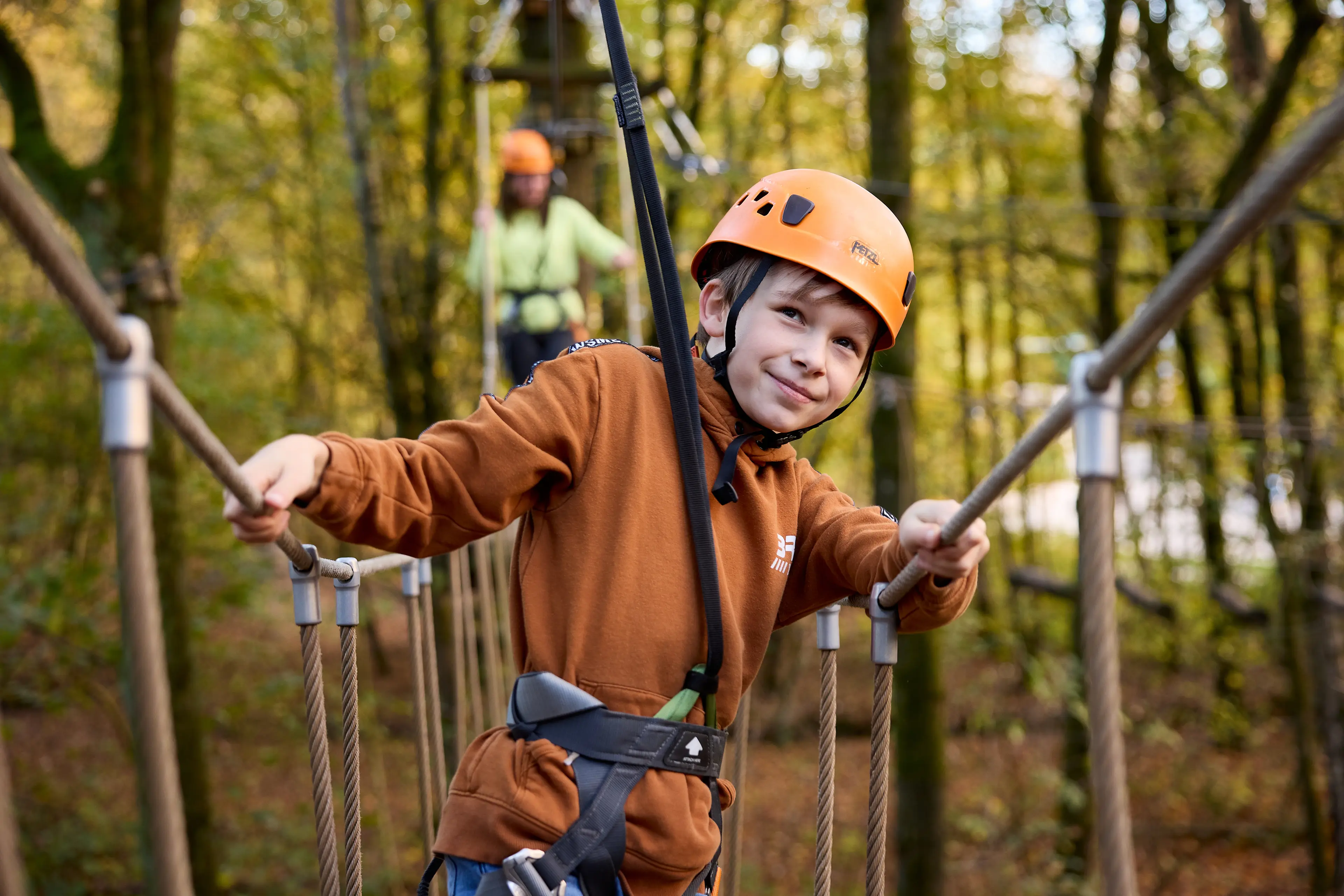 Een jongen klimt op het klimparcours bij Klimrijk Brabant