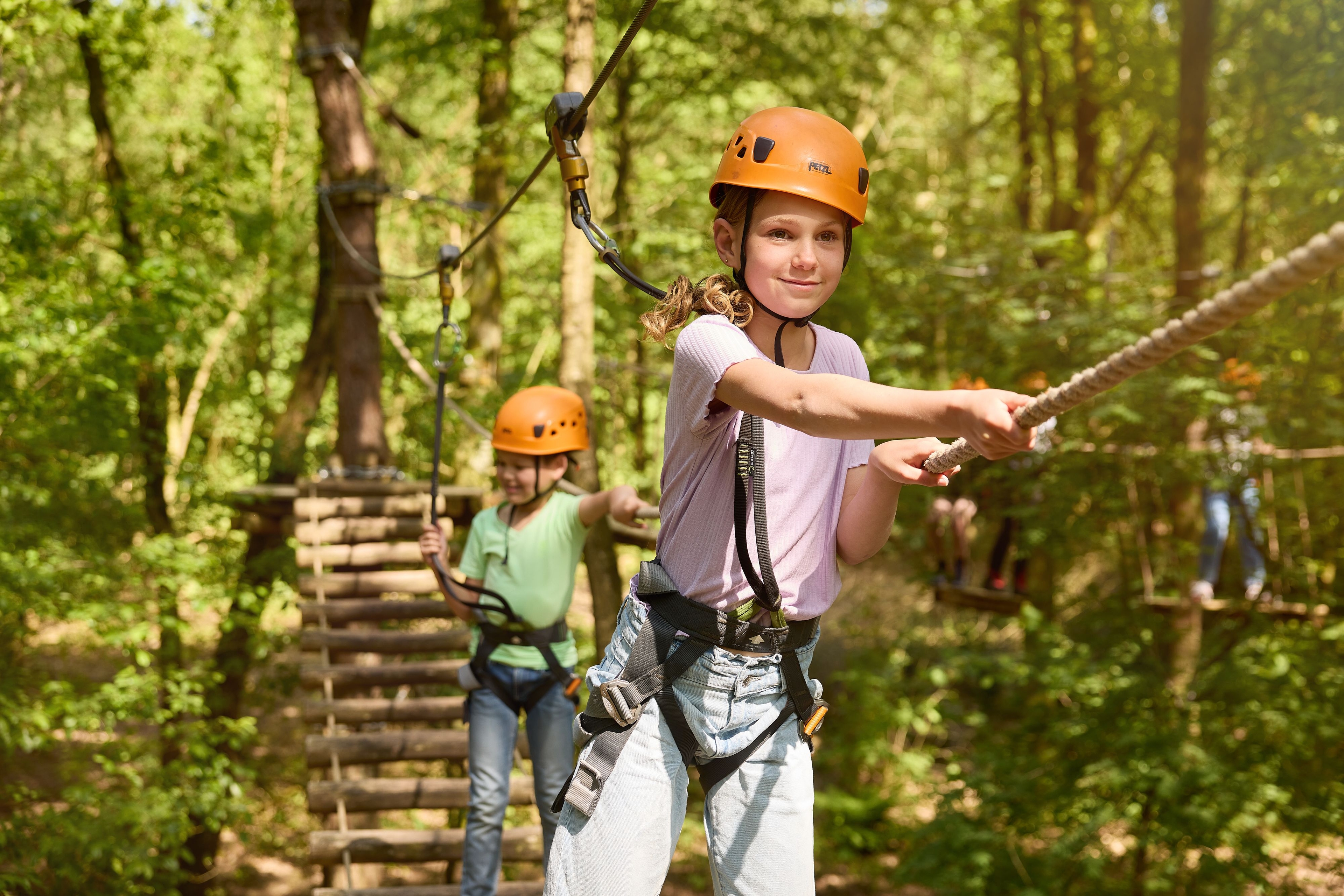 Kinderen op een hangbrug op het klimparcours bij Klimrijk Brabant