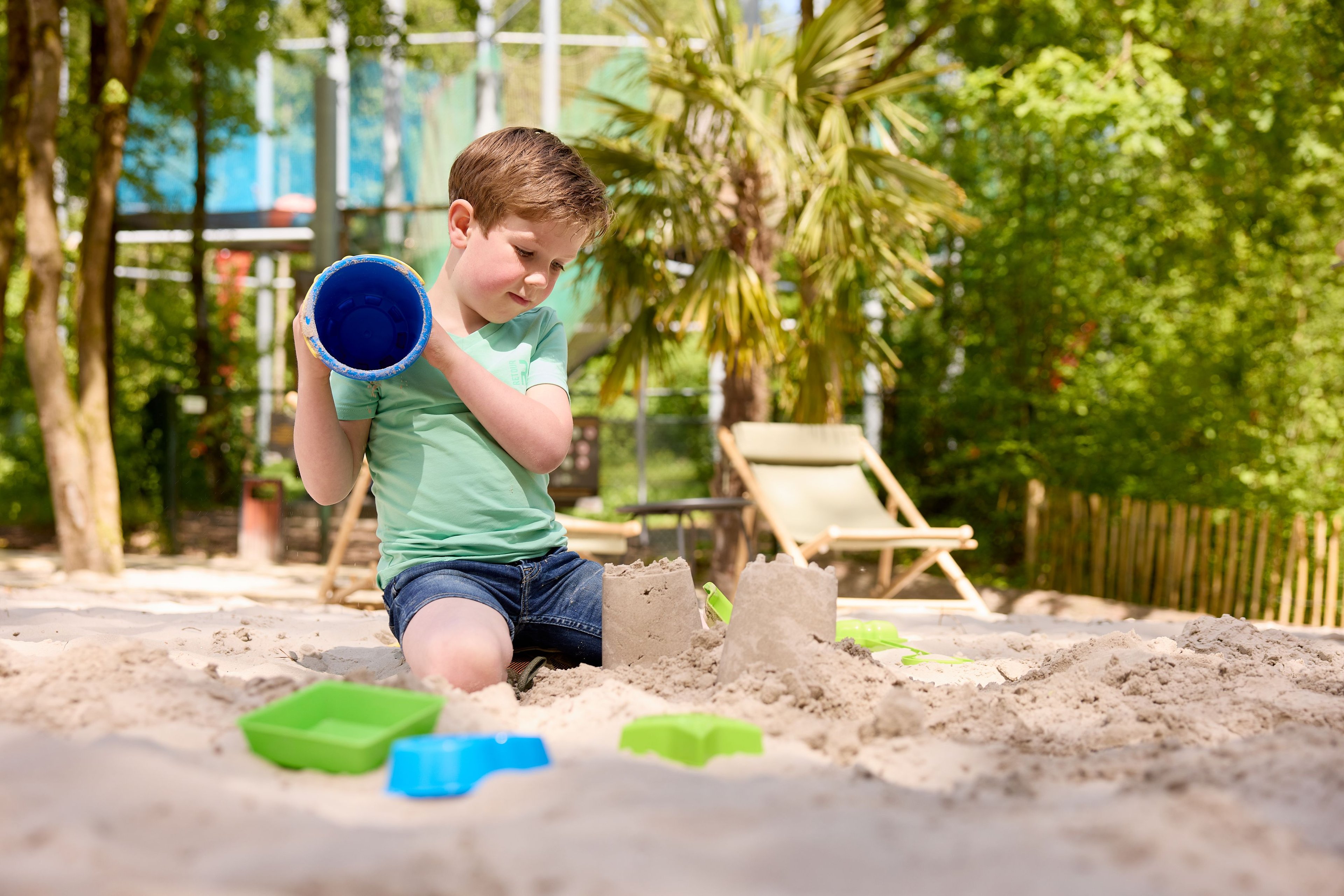 Kind aan het spelen op het zandstrand van de Beach Area bij Klimrijk Brabant