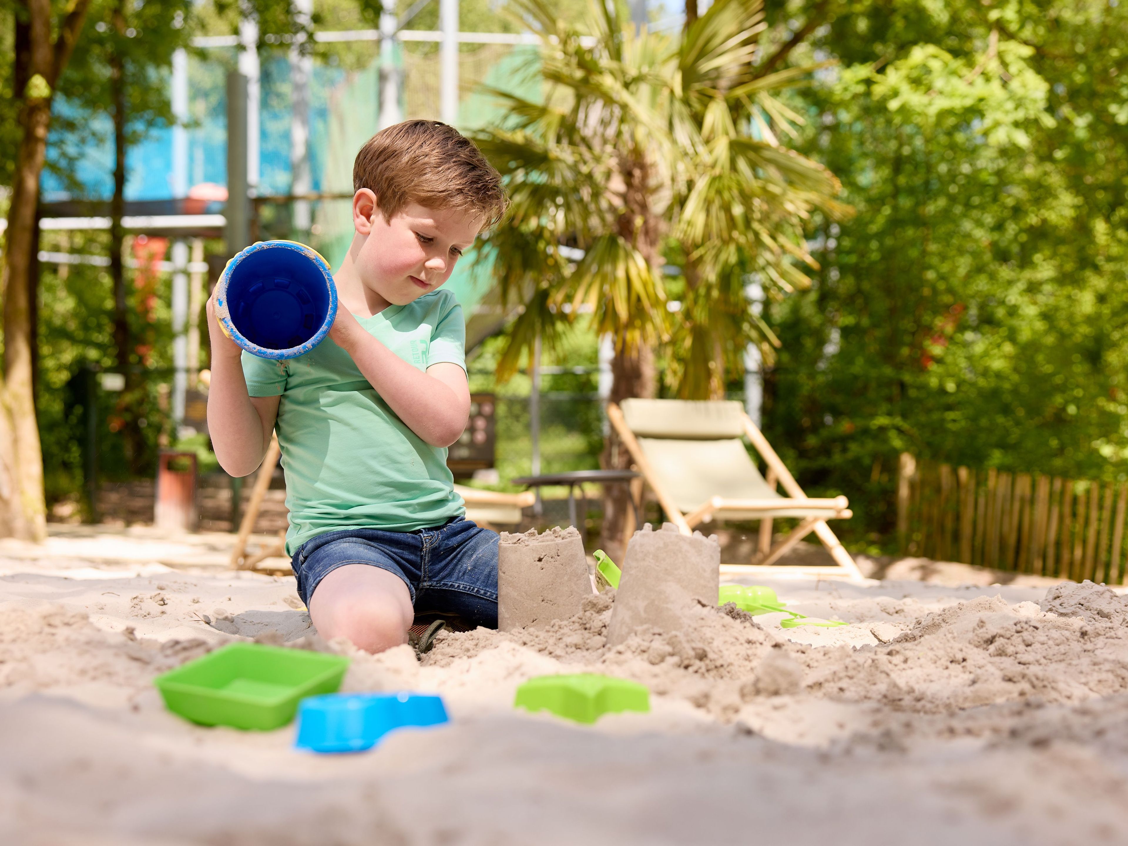 Kind aan het spelen op het zandstrand van de Beach Area bij Klimrijk Brabant