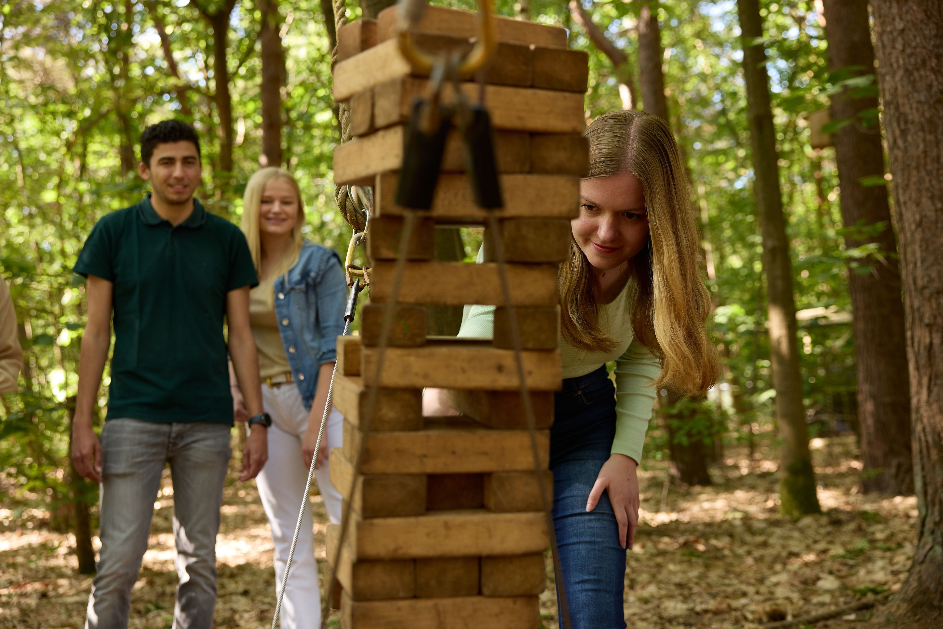 Vrouw speelt djenga tijdens Expeditie Buitenjan bij Klimrijk Brabant