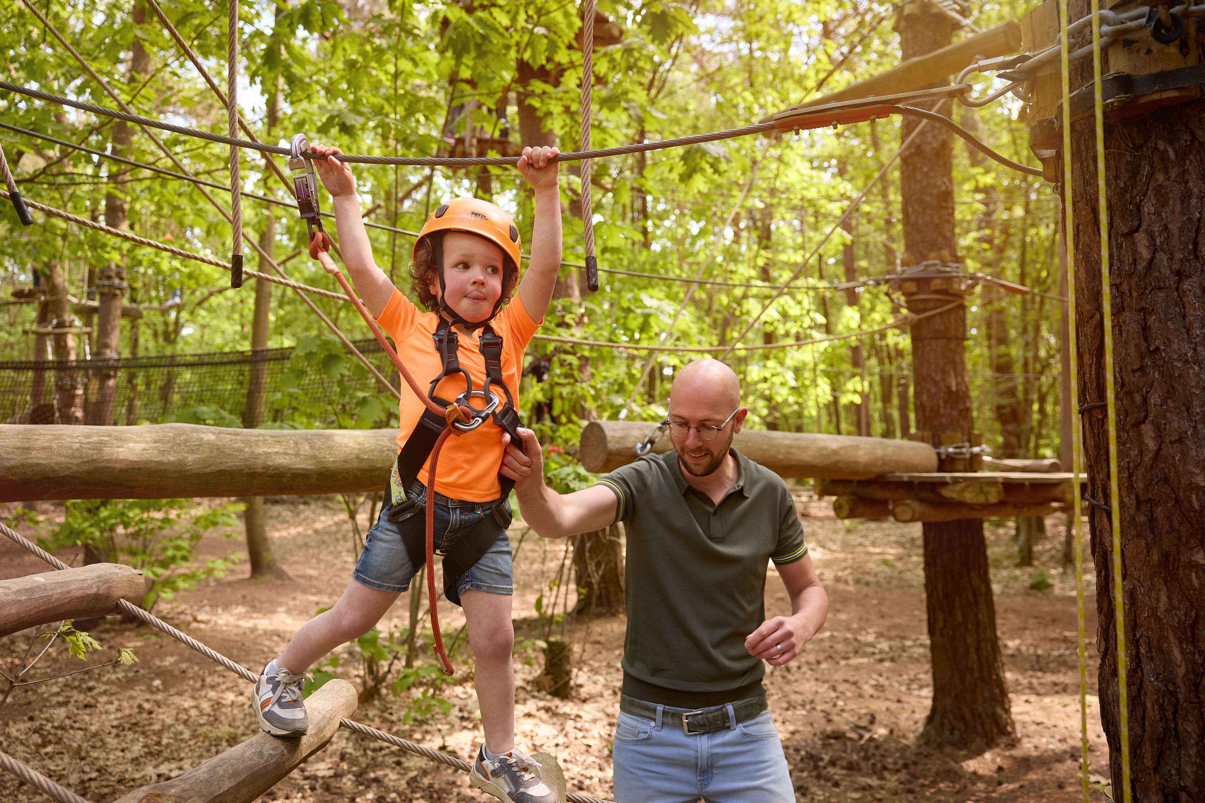 Vader begeleid kind op Pico-parcours bij Klimrijk Brabant