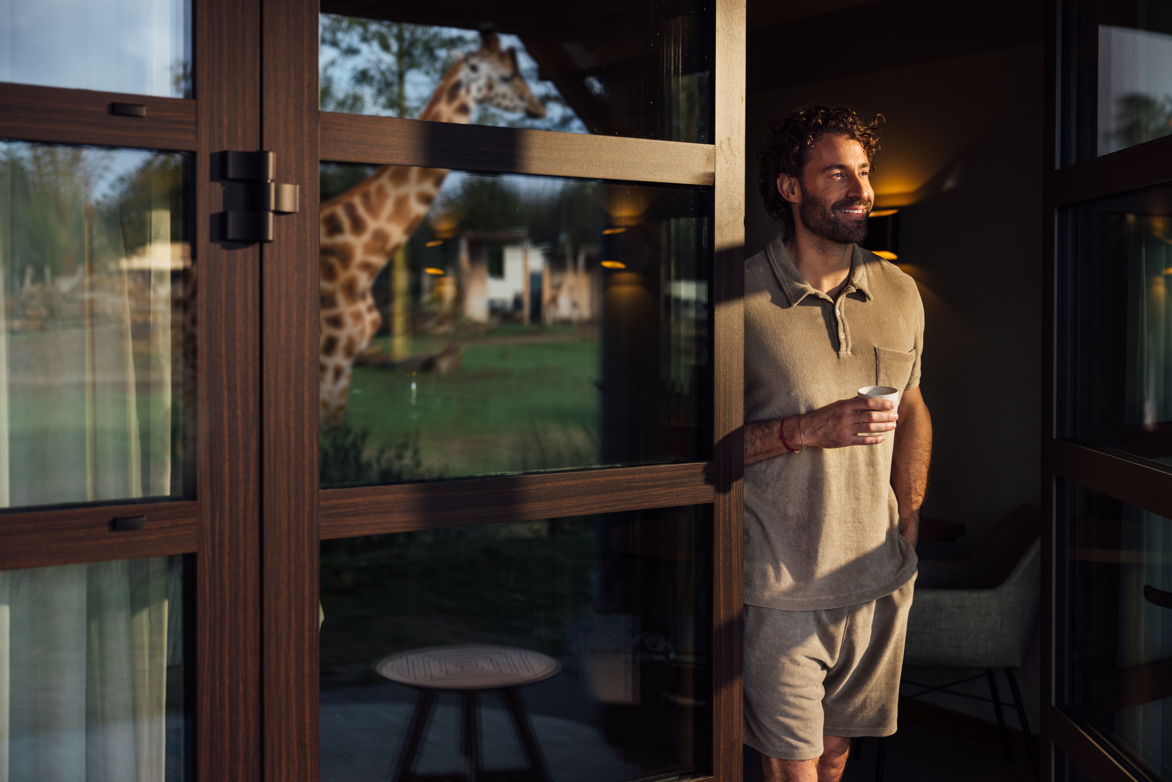 Een man drinkt koffie op het terras bij Safari Hotel Beekse Bergen.