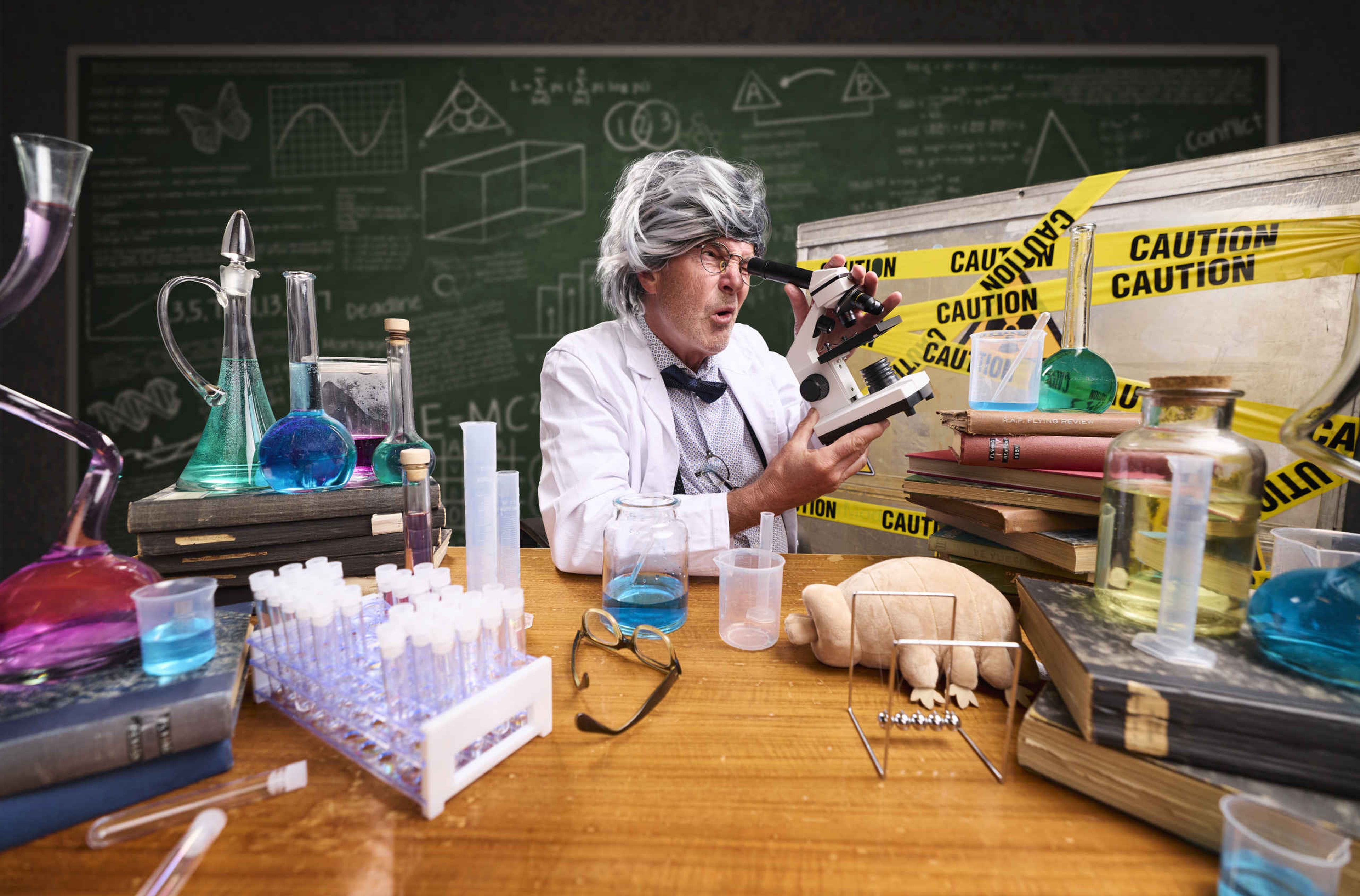 Een professor kijkt door een microscoop tijdens Space College bij Luchtvaartmuseum Aviodrome.